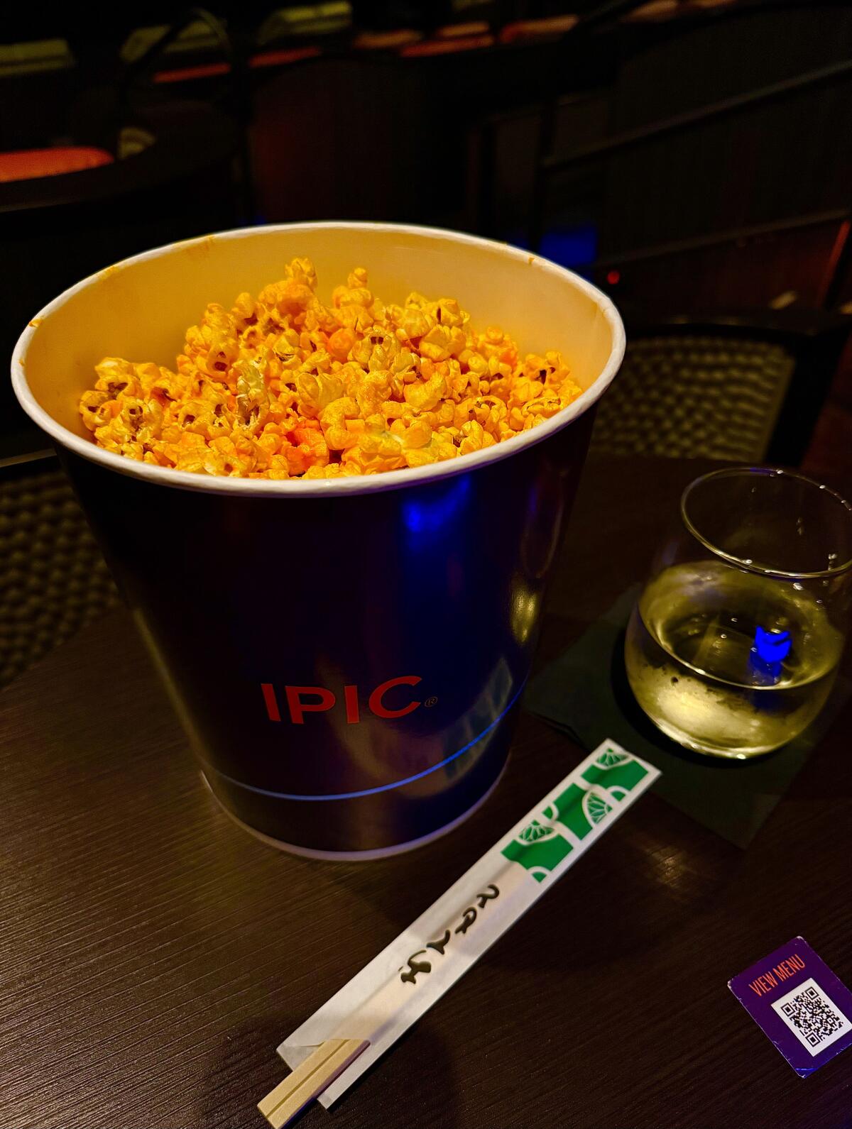 Cheese popcorn with a glass of wine and a pair of chopsticks from iPic theater in Pasadena.