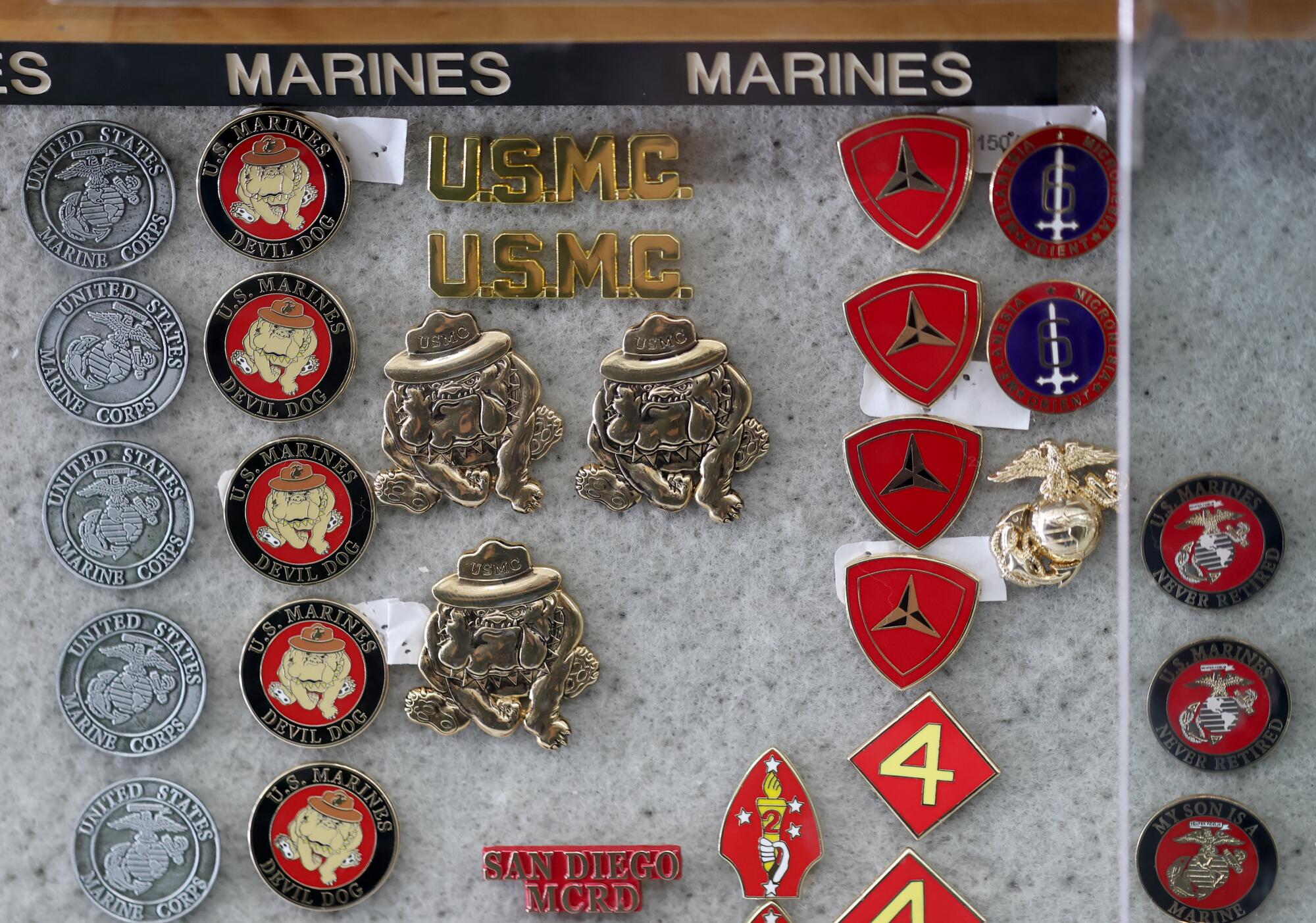 Marine pins are displayed in a shop cabinet. 