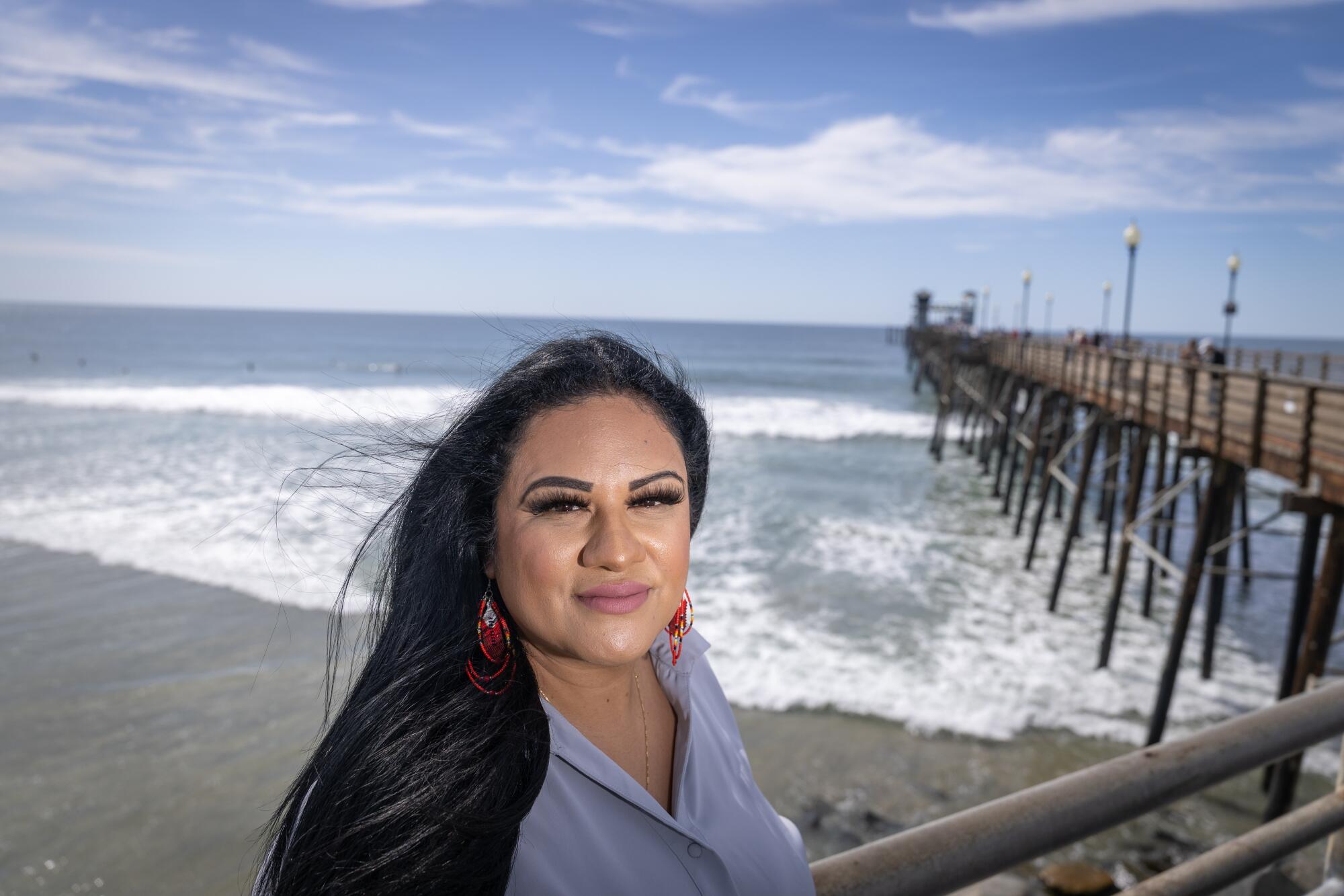 A woman poses for a portrait on a pier.