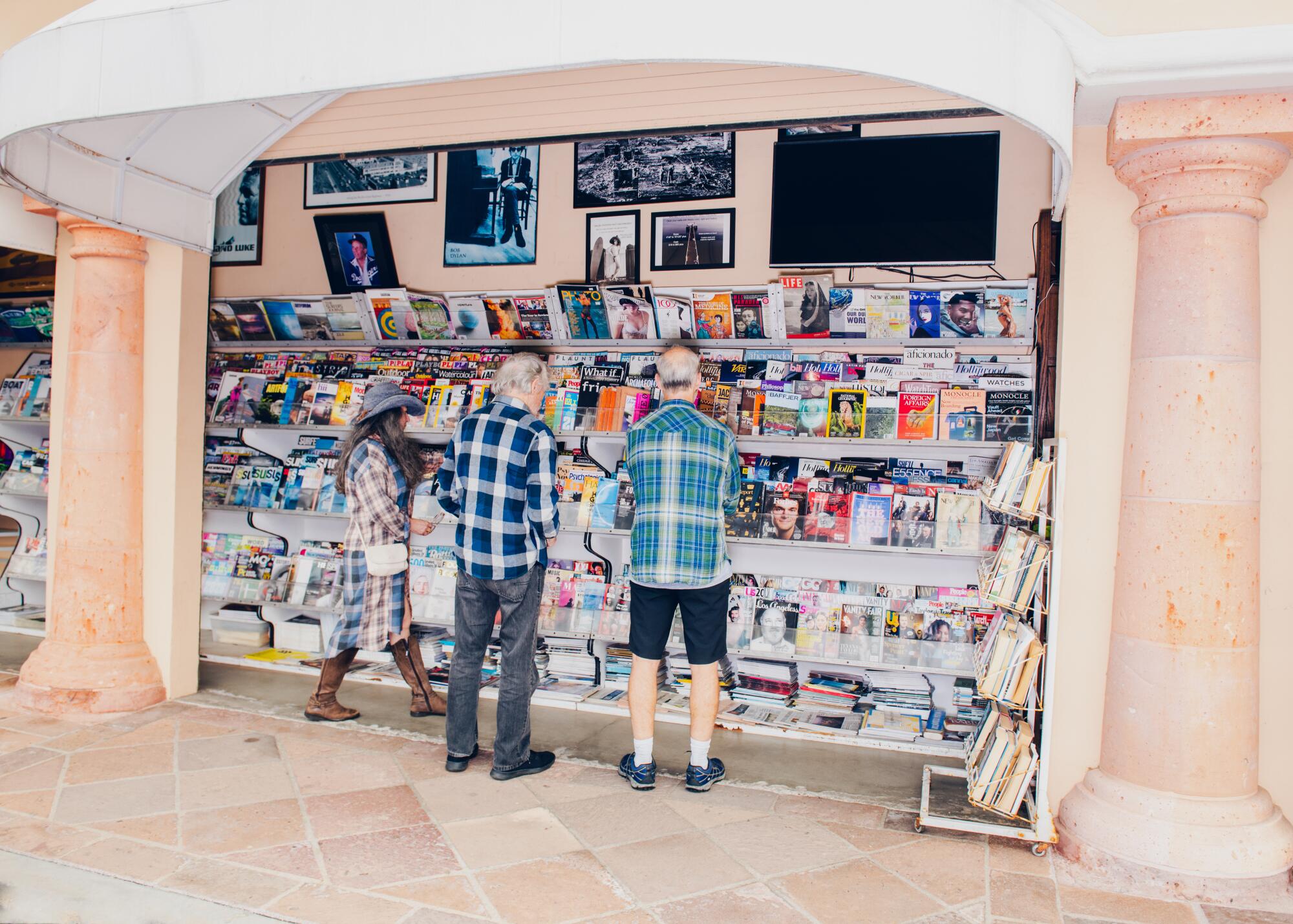 Customers look at magazines with owner Nathan Shields, right.