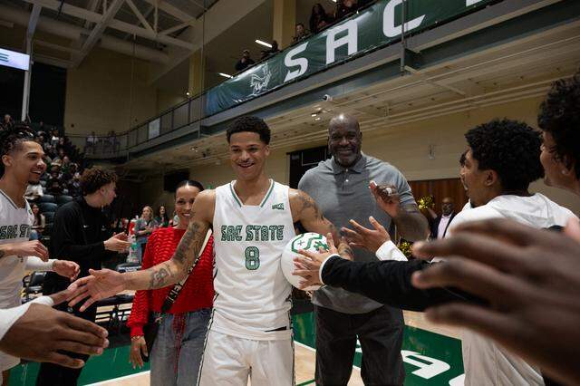 Sacramento State forward Shaqir O’Neal is joined by his parents, Shaunie Henderson and NBA legend Shaquille O’Neal, as they walk him onto the court Monday for a pregame ceremony as the team plays its final home game of the season. 