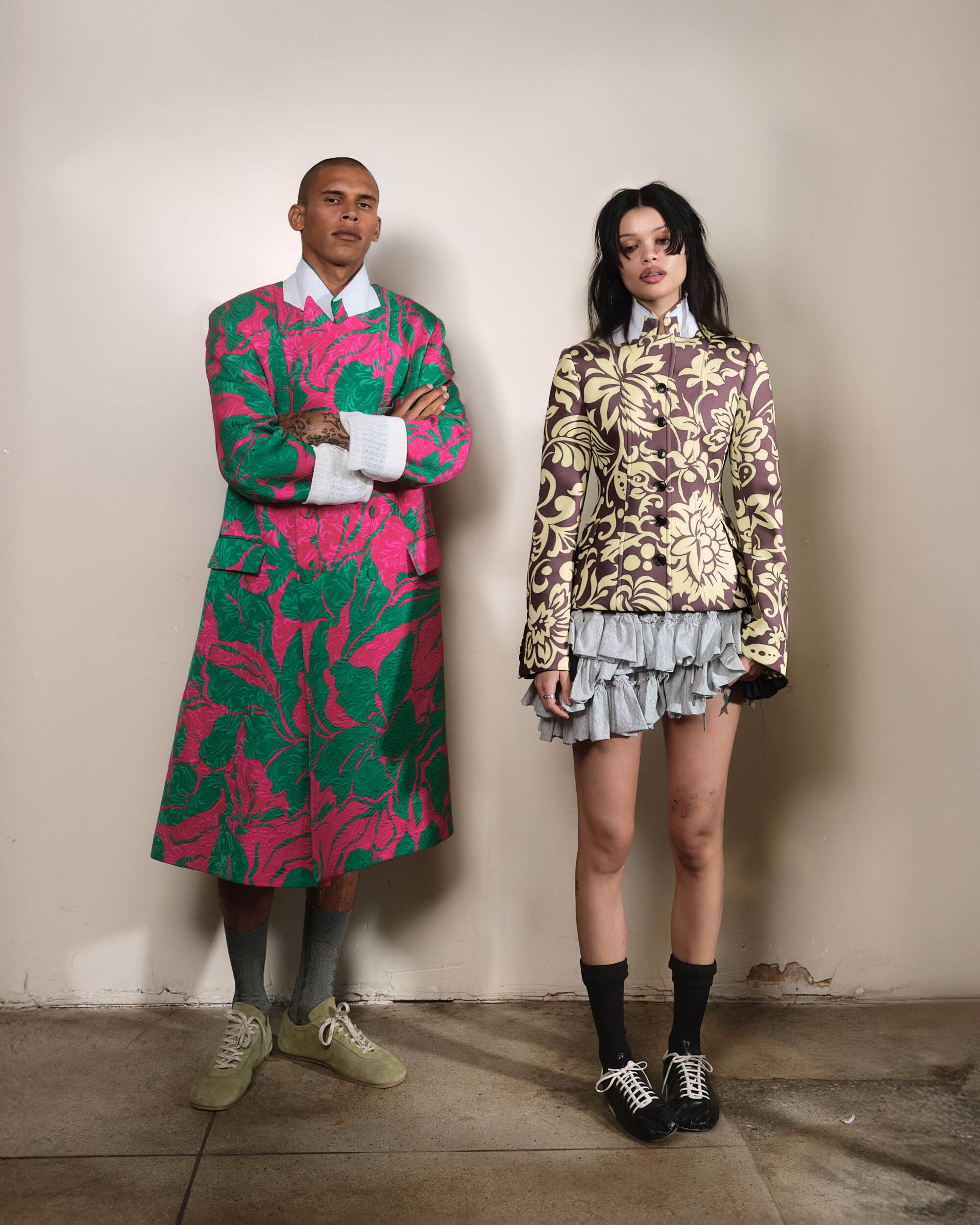 Daniel wears Dries Van Noten coat, shorts, sneakers and socks. Sirena wears Dries Van Noten jacket, micro shorts and sneakers