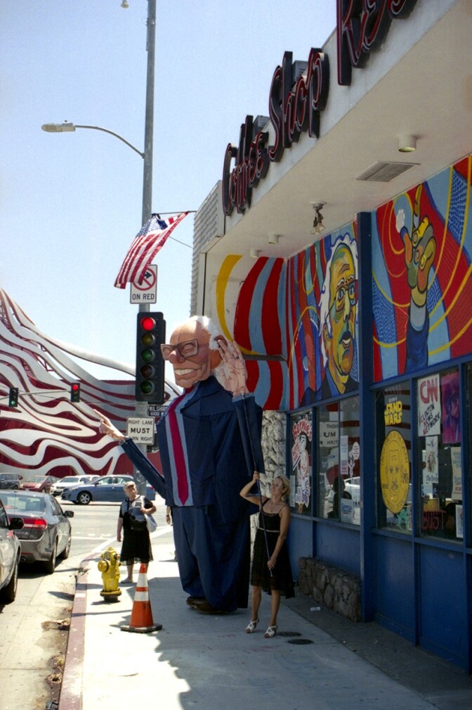 An effigy of Bernie Sanders outside a diner with Bernie Sanders-themed art on the outside walls and windows.