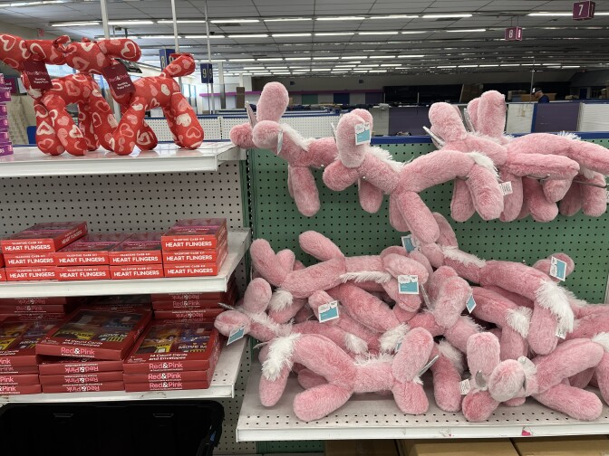 Balloon-animal shaped plushies and candy on store market shelves.
