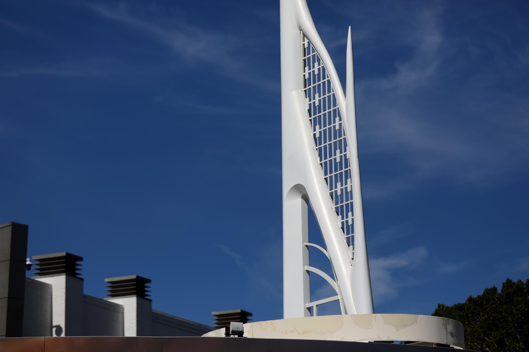 A white tower in front of a blue sky.