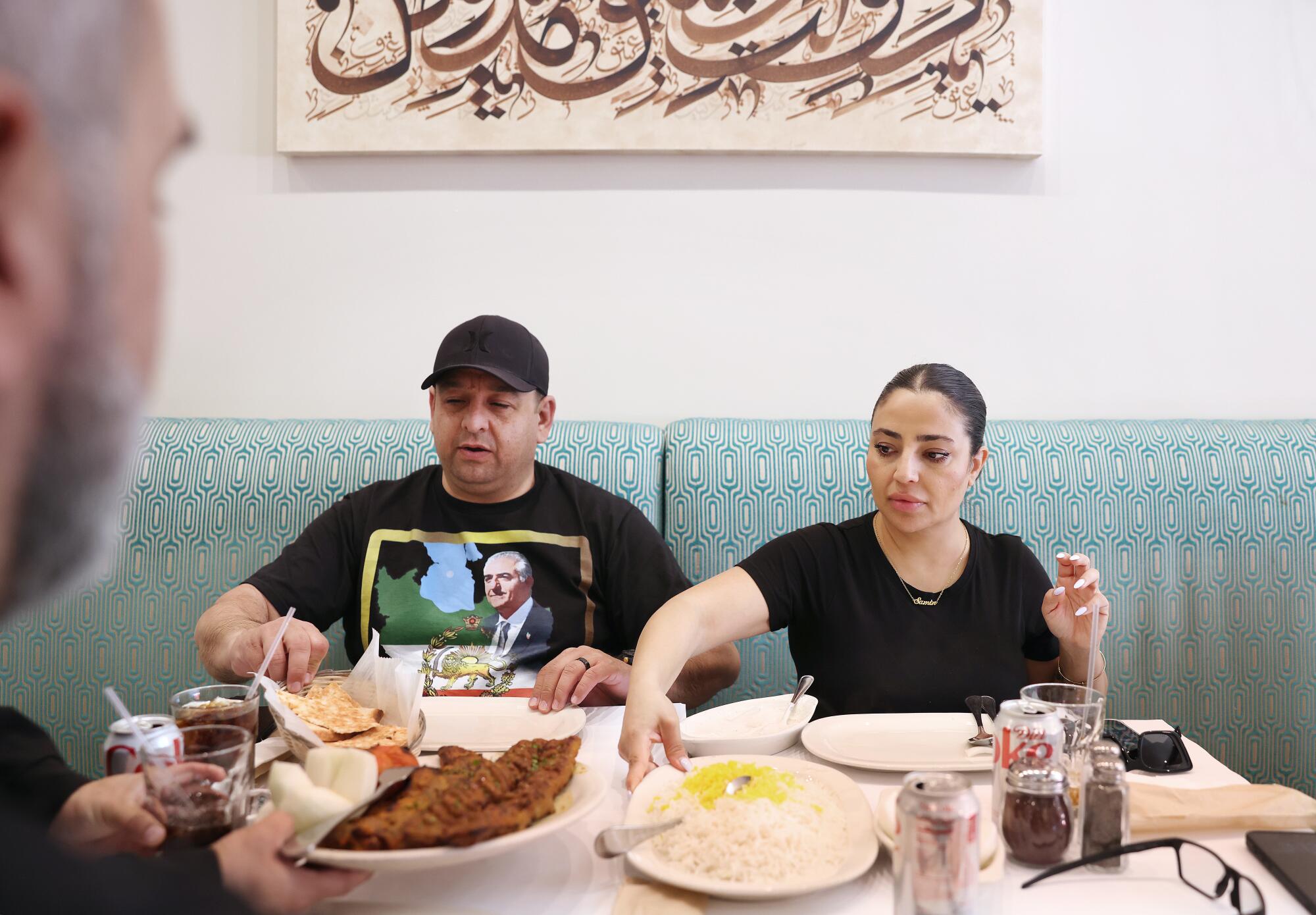 A group of three eat dinner.