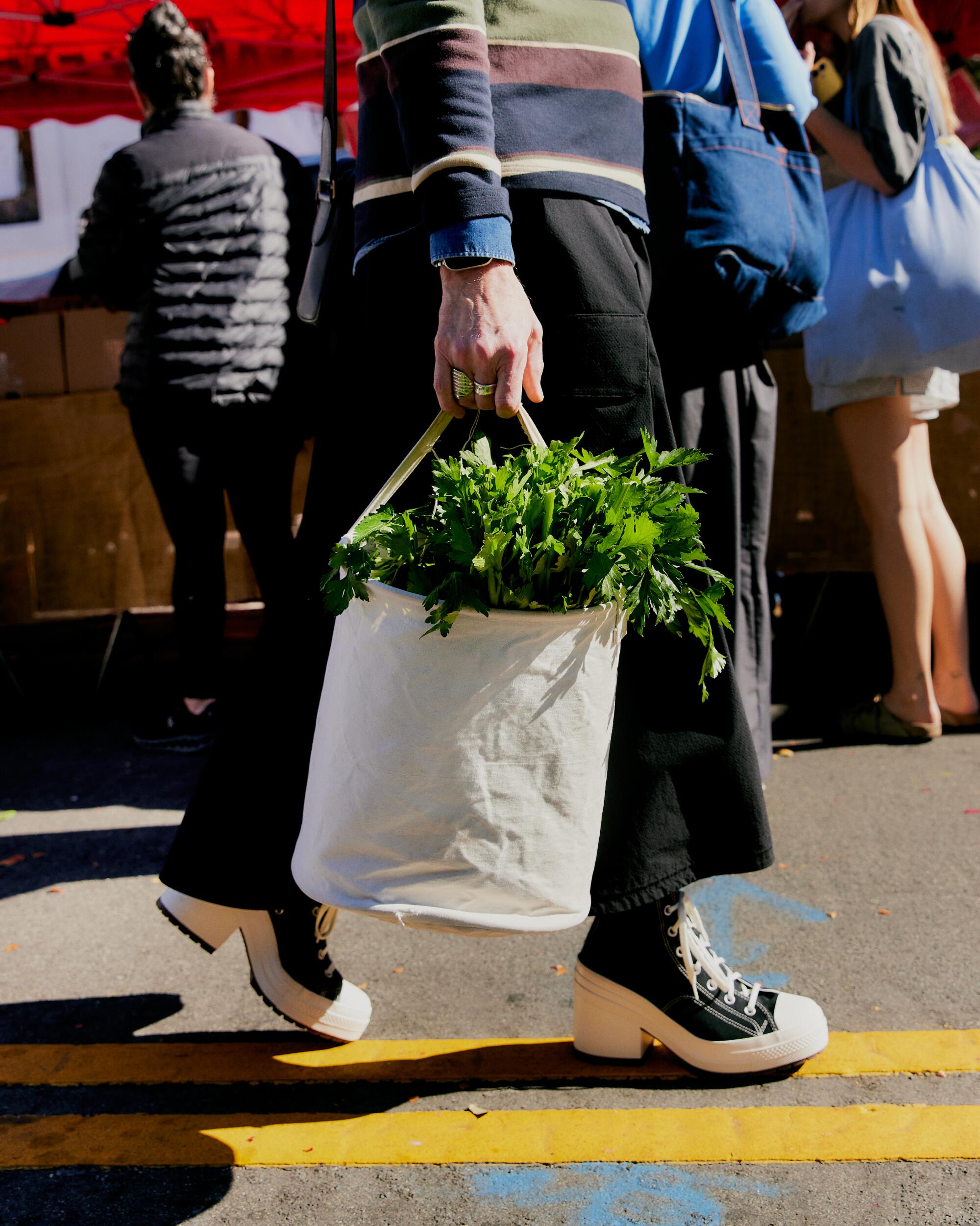 Cameron Crotty wears Liberty London sweater, Adidas skirt, and Converse Chuck 70 De Luxe Heel High Top sneakers.