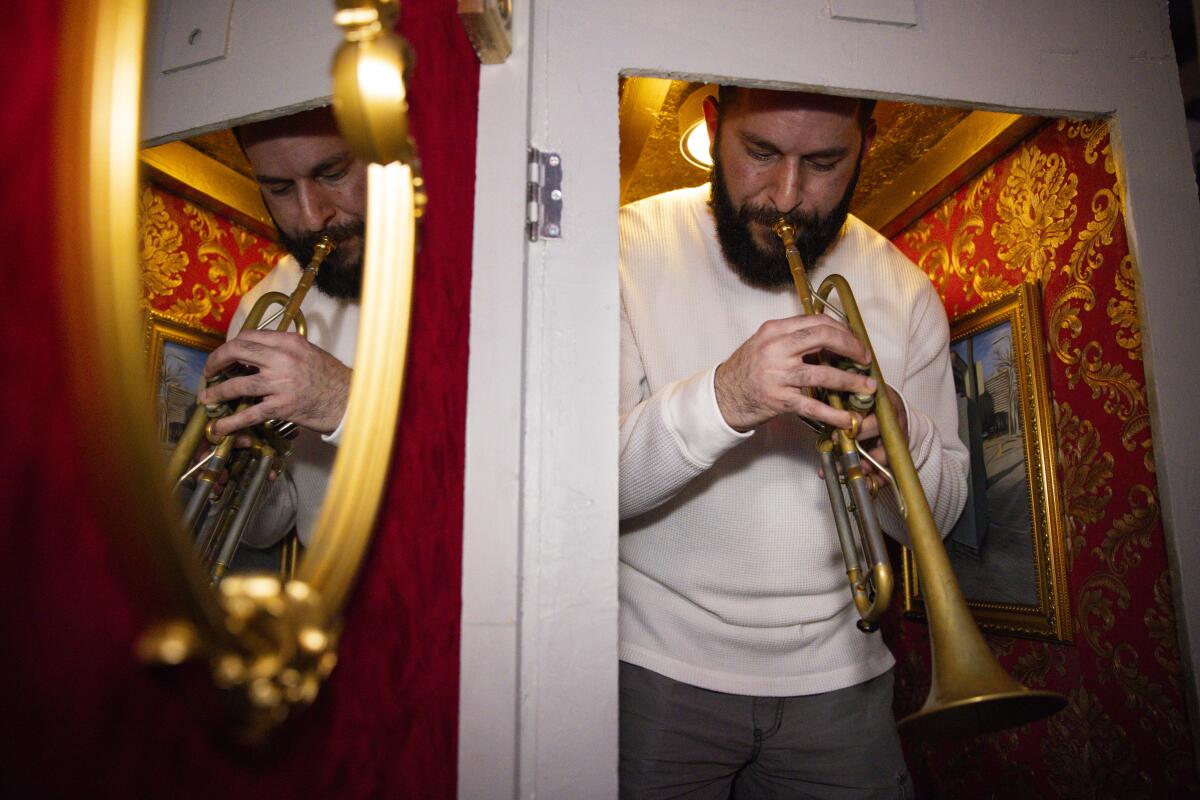 A musician plays a trumpet inside a former electrical box that was converted into an intimate stage for one