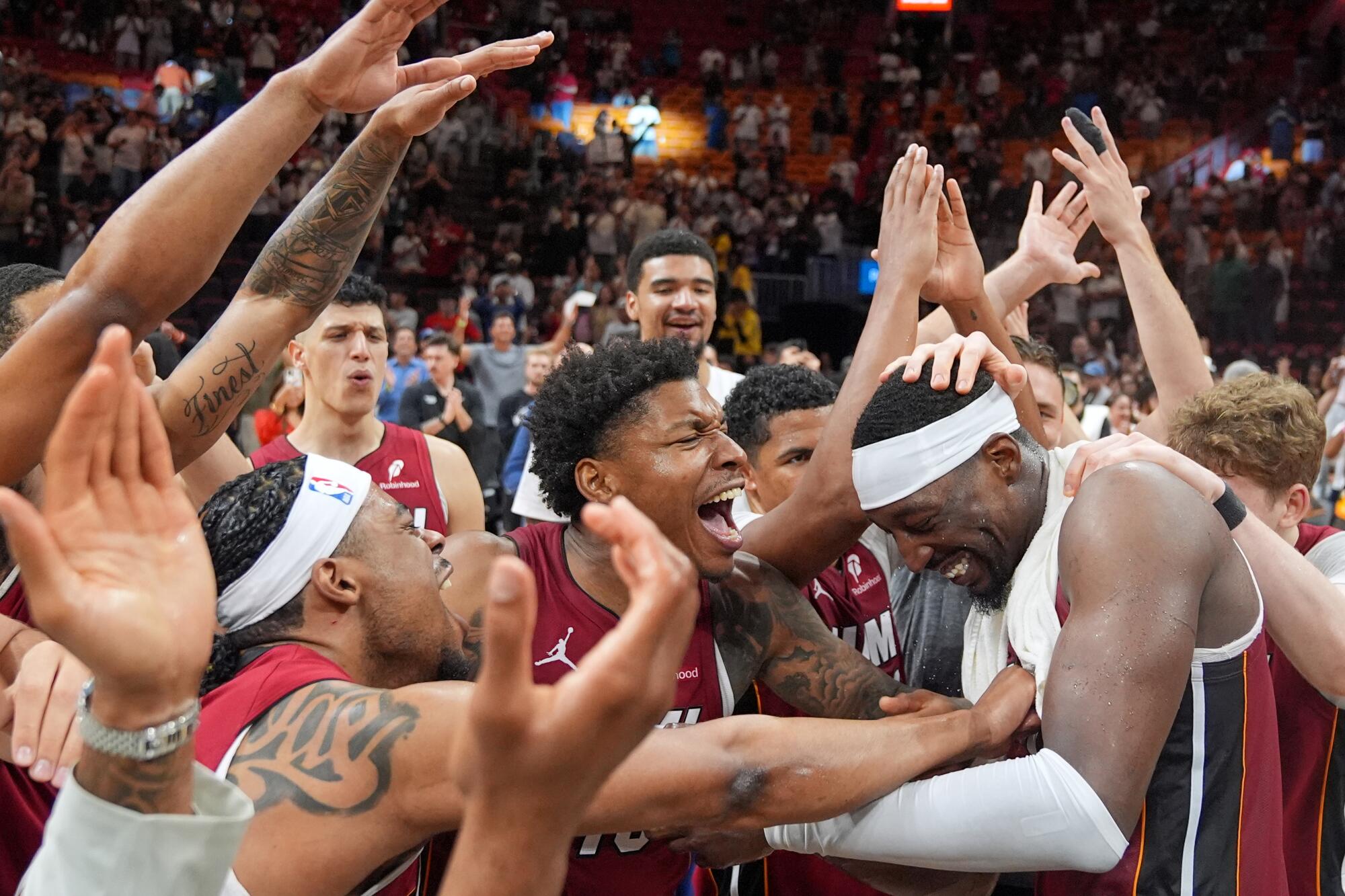 Heat players celebrate with center Bam Adebayo after he scored 83 points against the Wizards on Tuesday in Miami. 