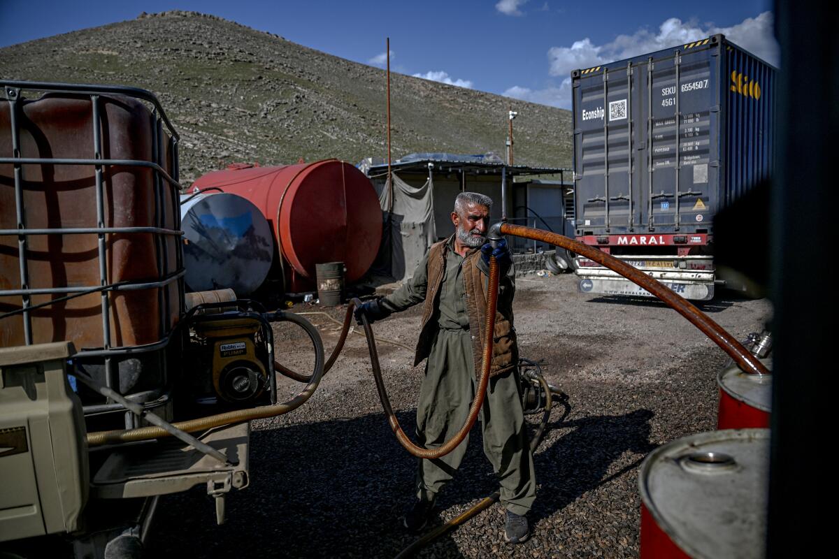 A vendor pumps petrol from tankers.