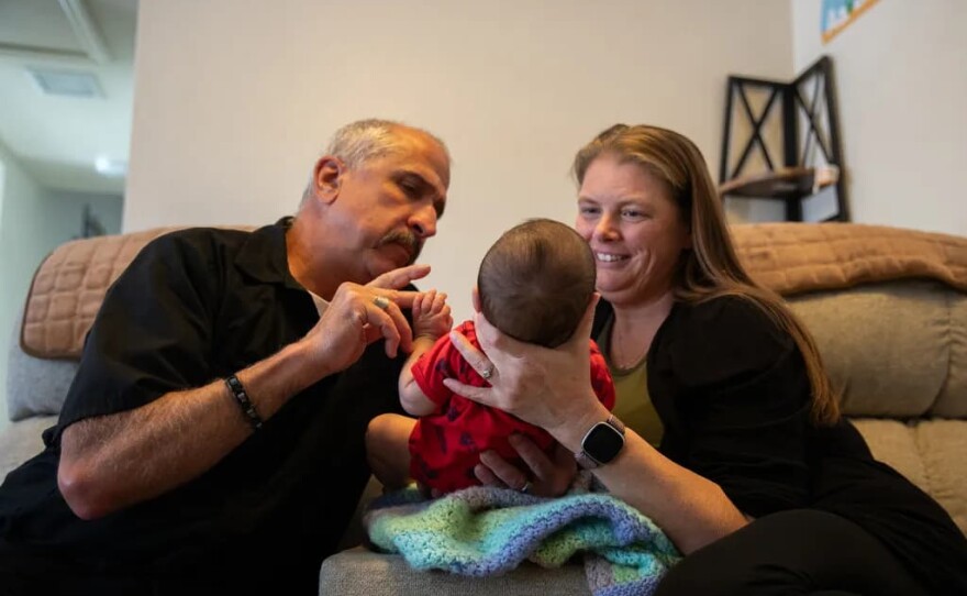 Tony and Sara Iagmin play with the baby they are fostering at their home in San Diego’s Lakeside neighborhood on Feb. 23, 2026.