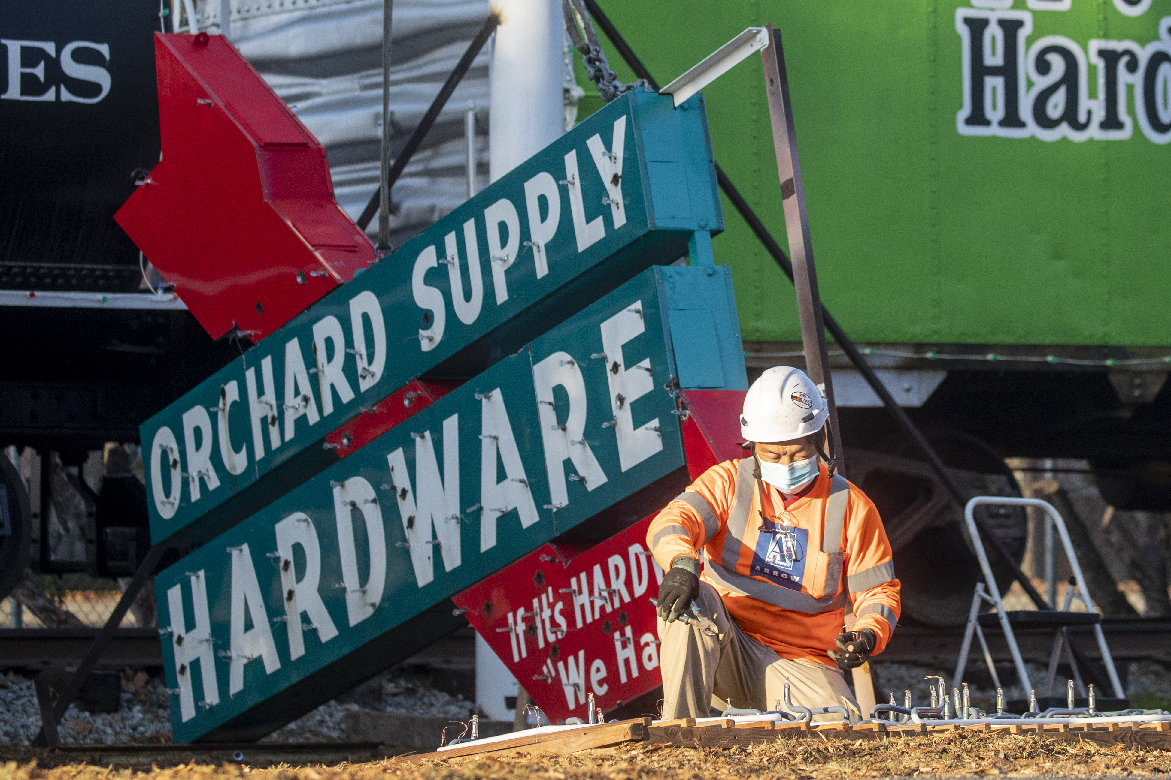 Chao Vang of Arrow Sign Company inspects tubes being installed...