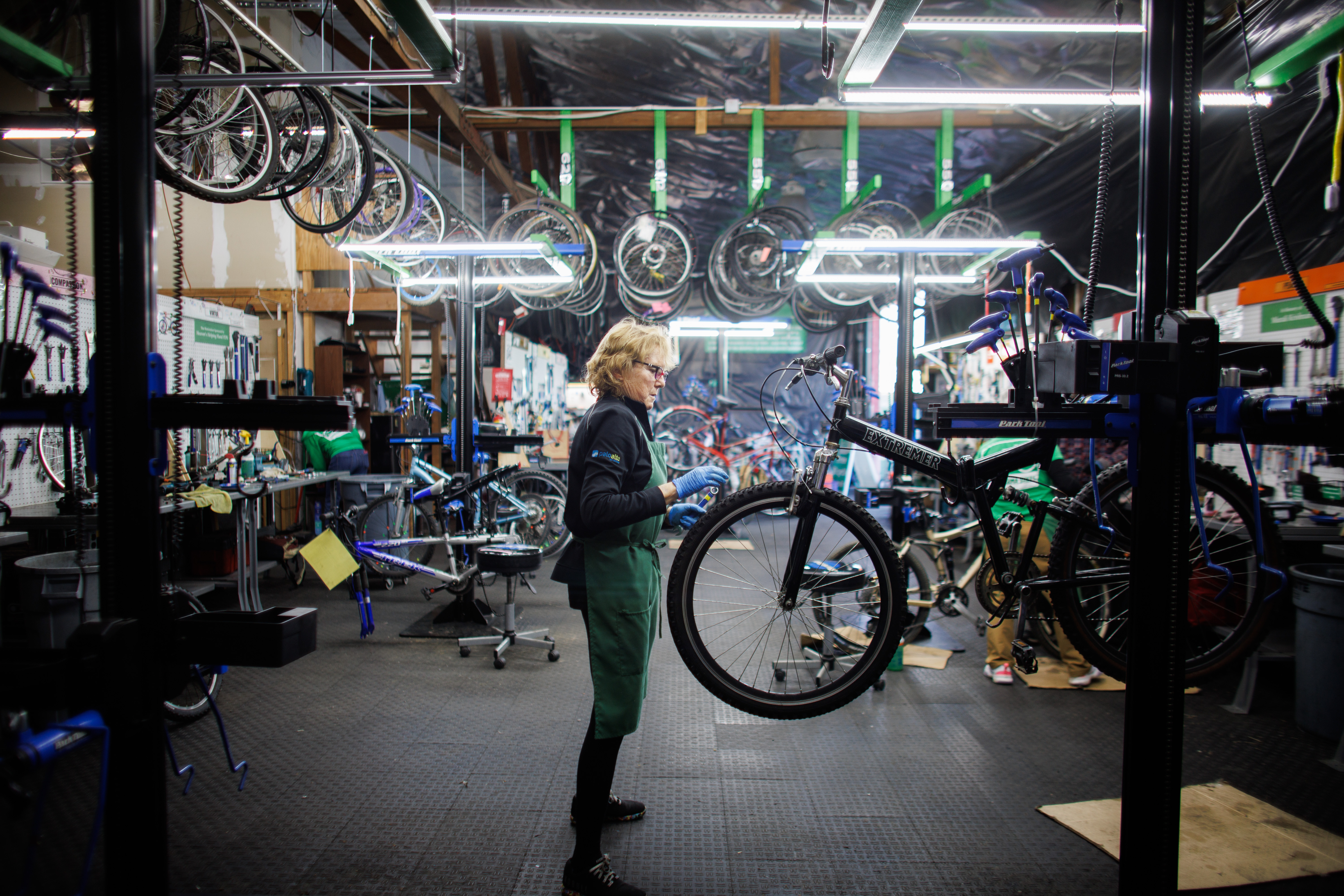 Good Karma Bikes volunteer mechanic Joanne Ottney works on a...