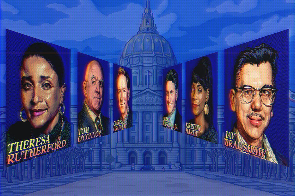 A man with curly dark hair and light facial hair wears a white shirt featuring large blue fish illustrations.