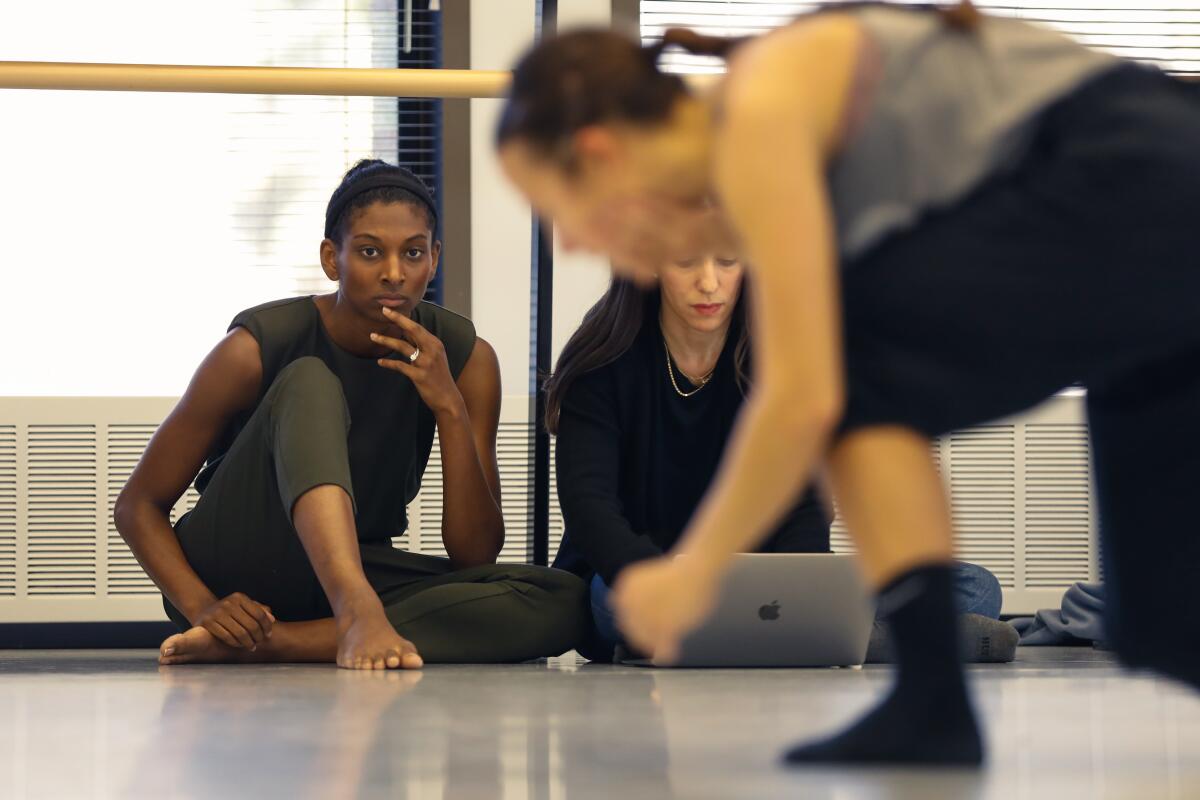 A choreographer watches a dancer.