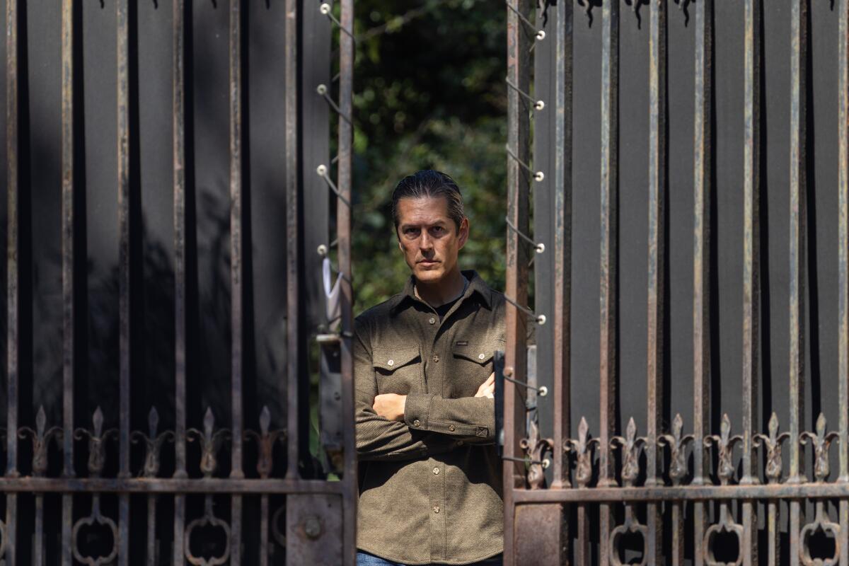 A security guard stands at the gate of the Paramour Estate