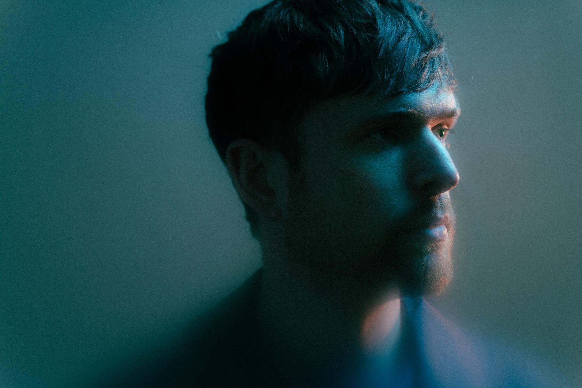 A close-up of James Blake, who looks off to the right