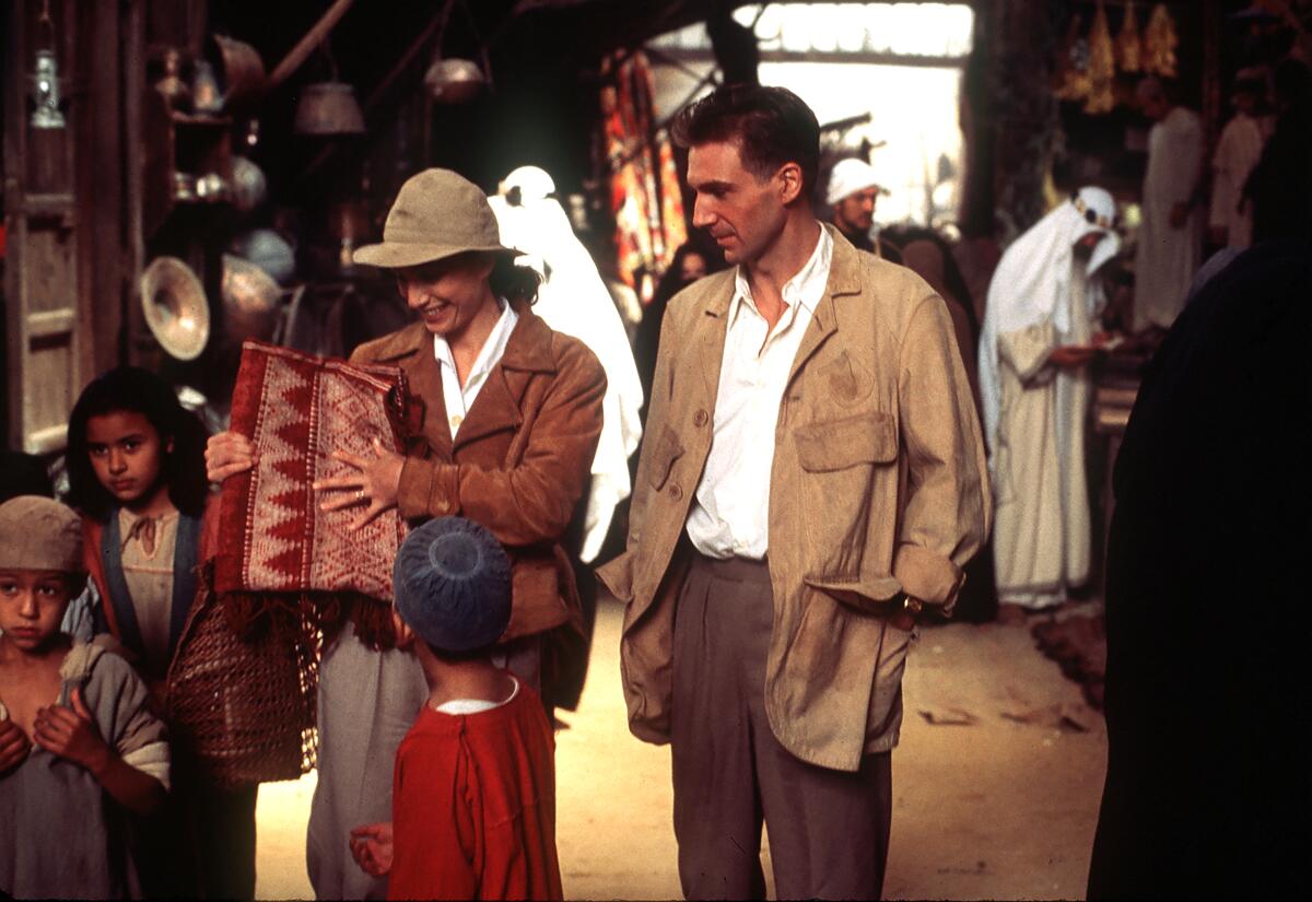 Two people stroll in an outdoor market.