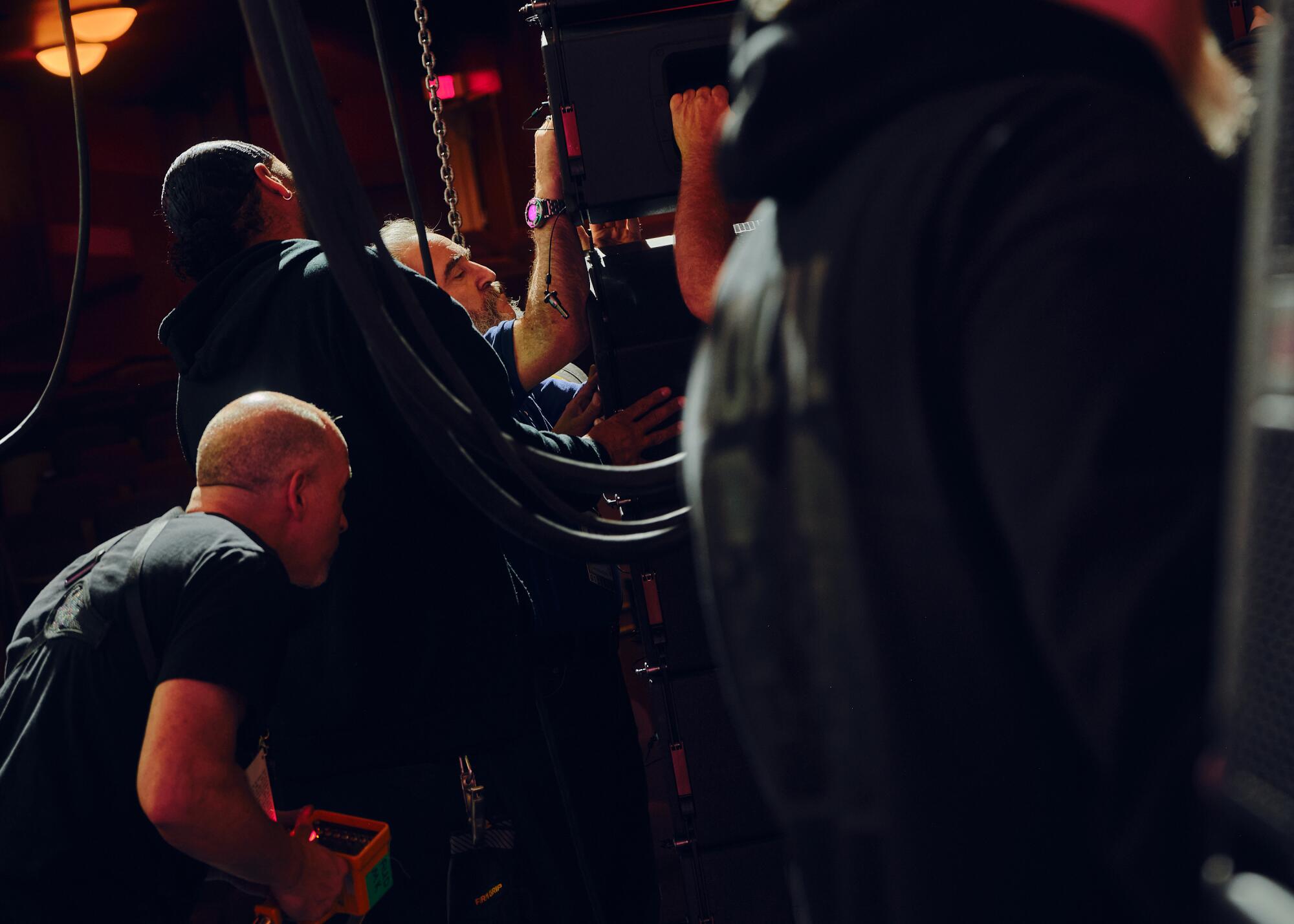 A crew moves a speaker system. 