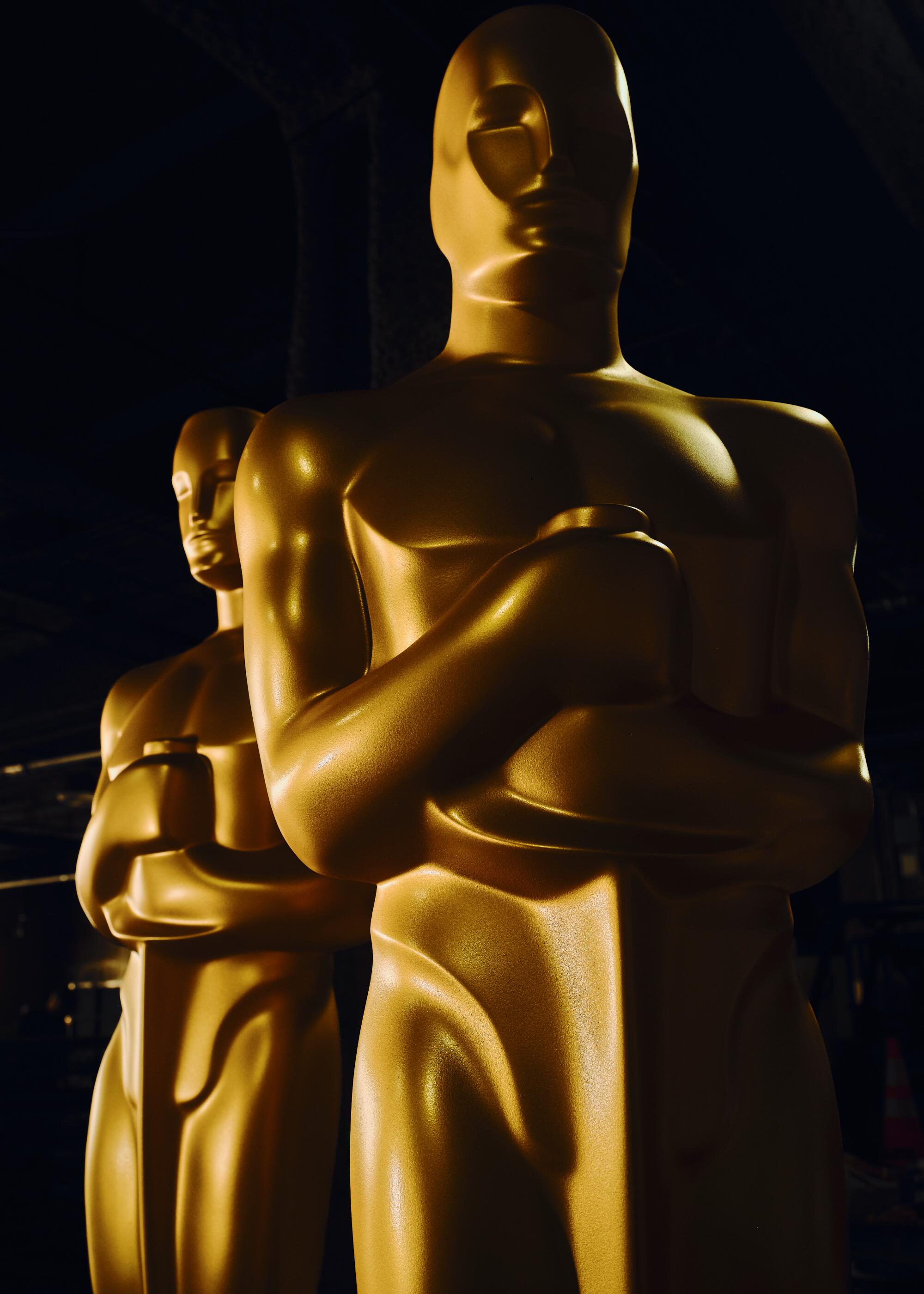 Two large golden Oscars statues are in frame. 