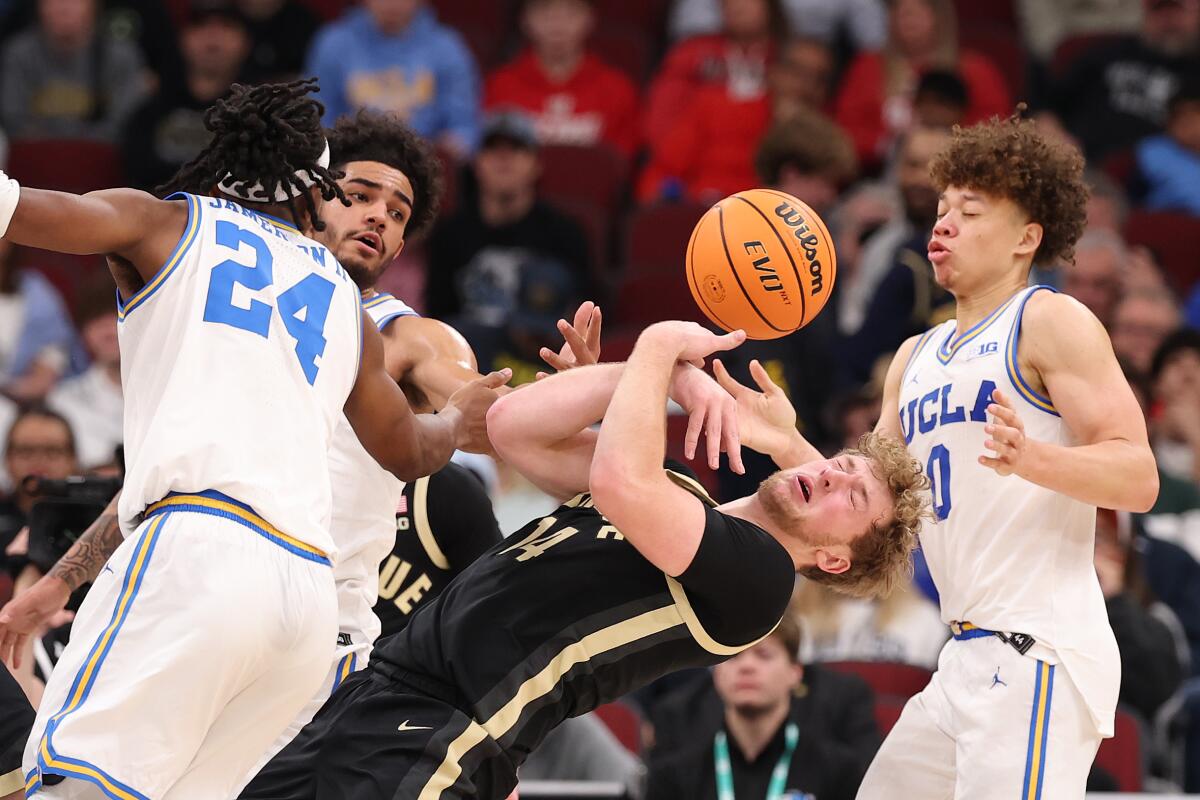 UCLA's Trent Perry, right, and Steven Jamerson II, left, battle Purdue's Jack Benter for a rebound on Saturday
