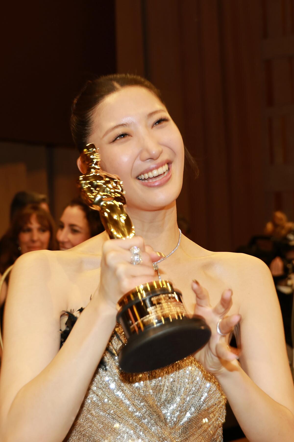 Ejae holds up her Oscar at the Governors Ball. 