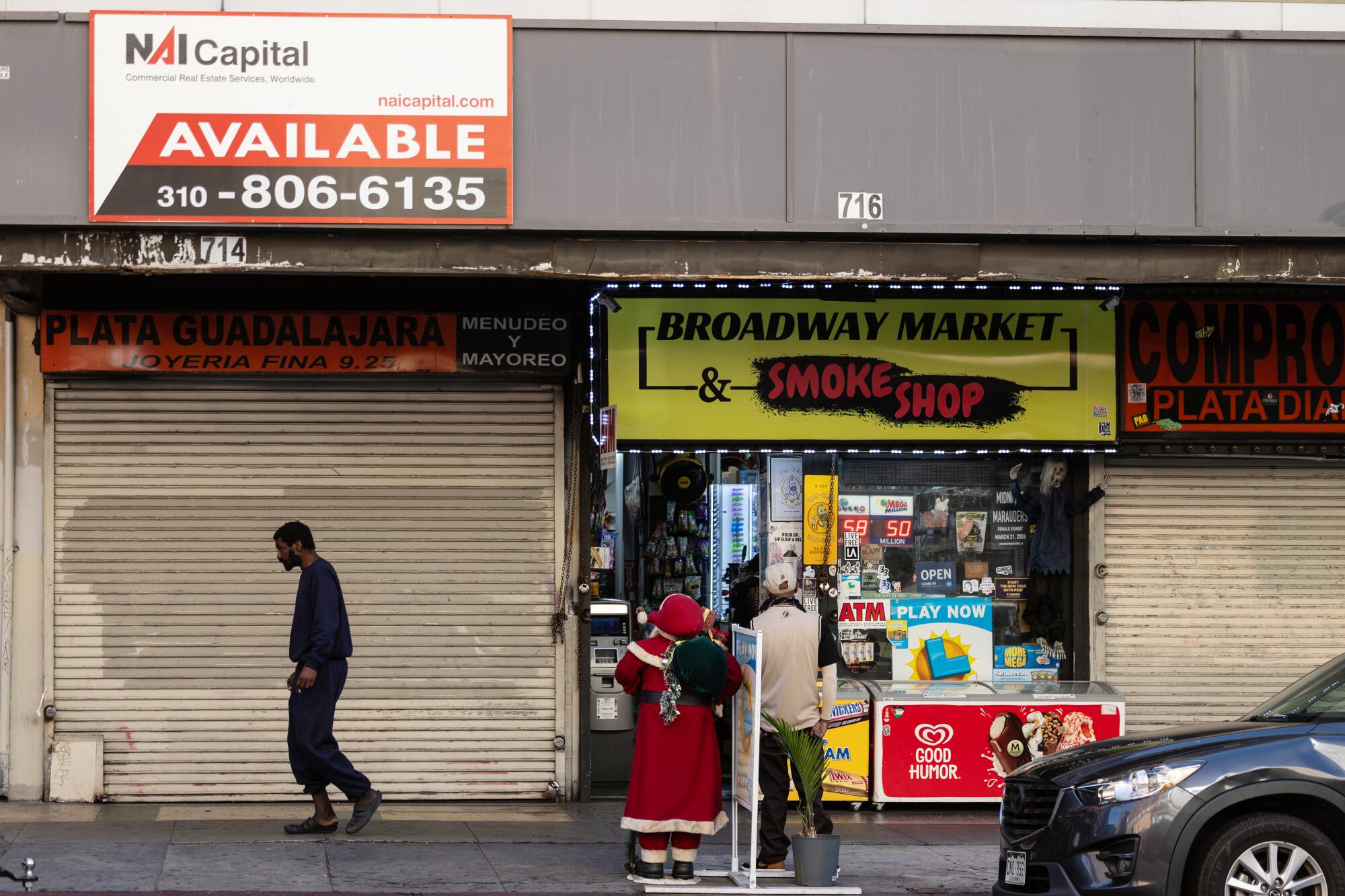 A pedestrian walks past shuttered stores on Broadway in Los Angeles.