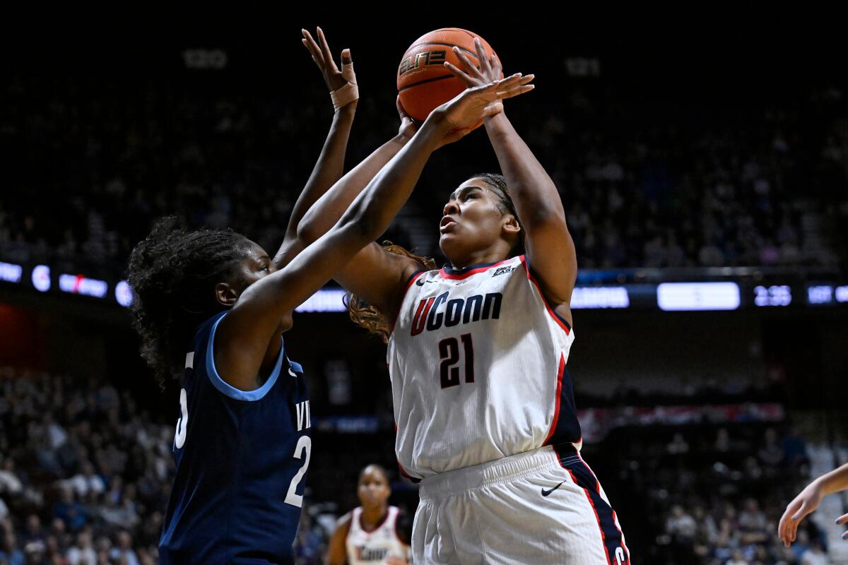 Connecticut forward Sarah Strong, right, shoots over Villanova forward Denae Carter.