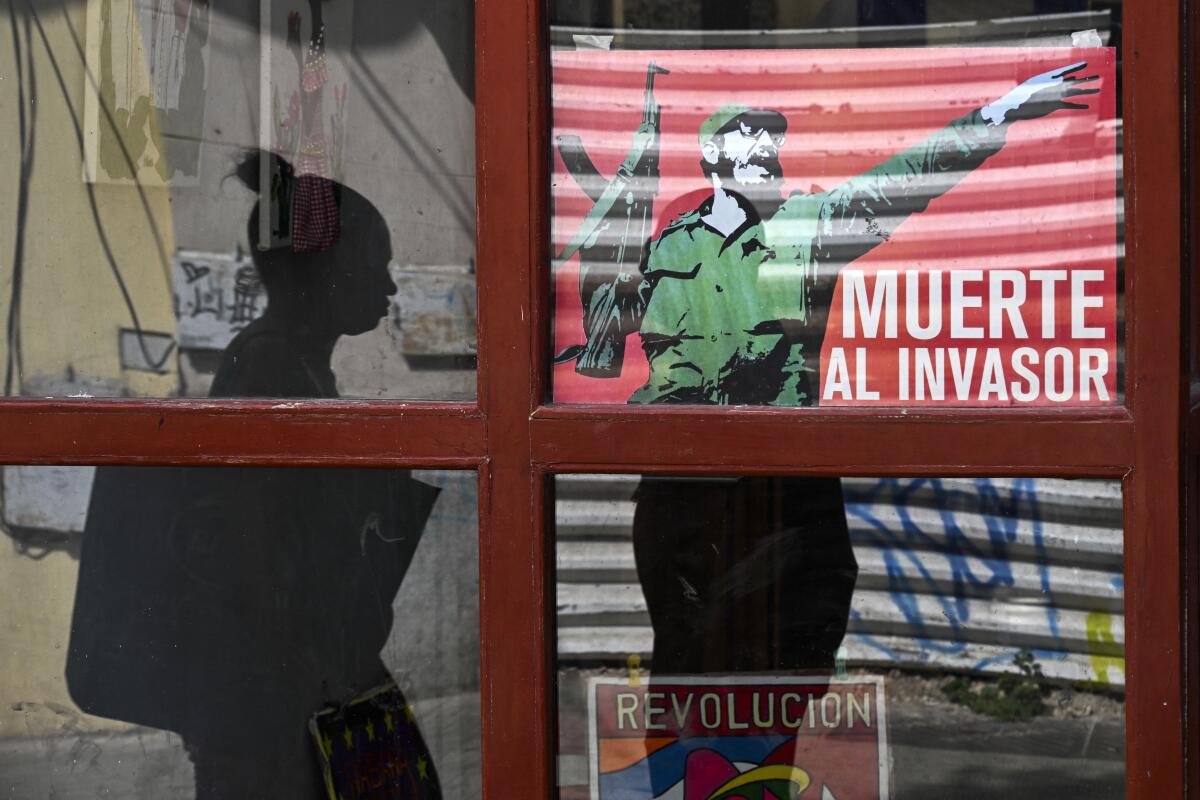 A woman walks past a window poster of late Cuban leader Fidel Castro.