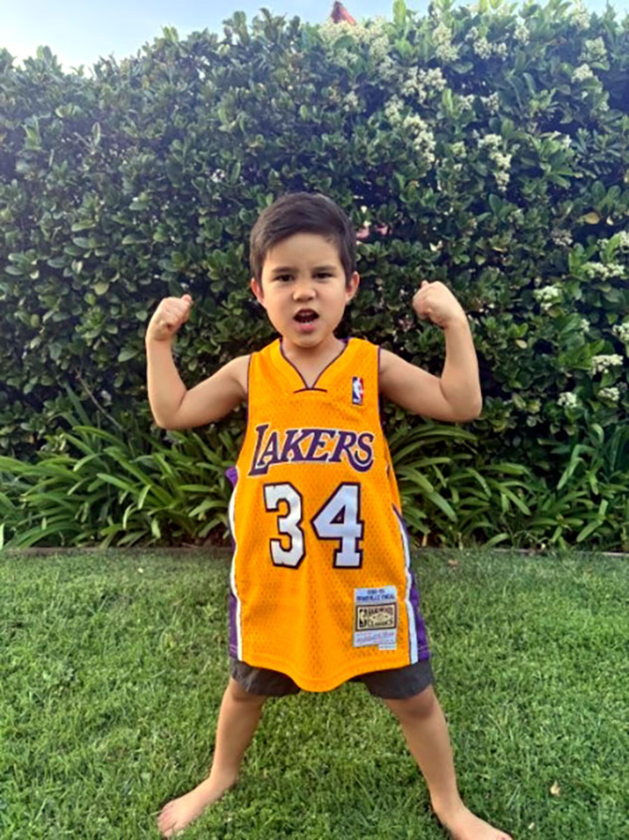 Jackson Tuyay cheers while standing in his backyard wearing a Lakers jersey.