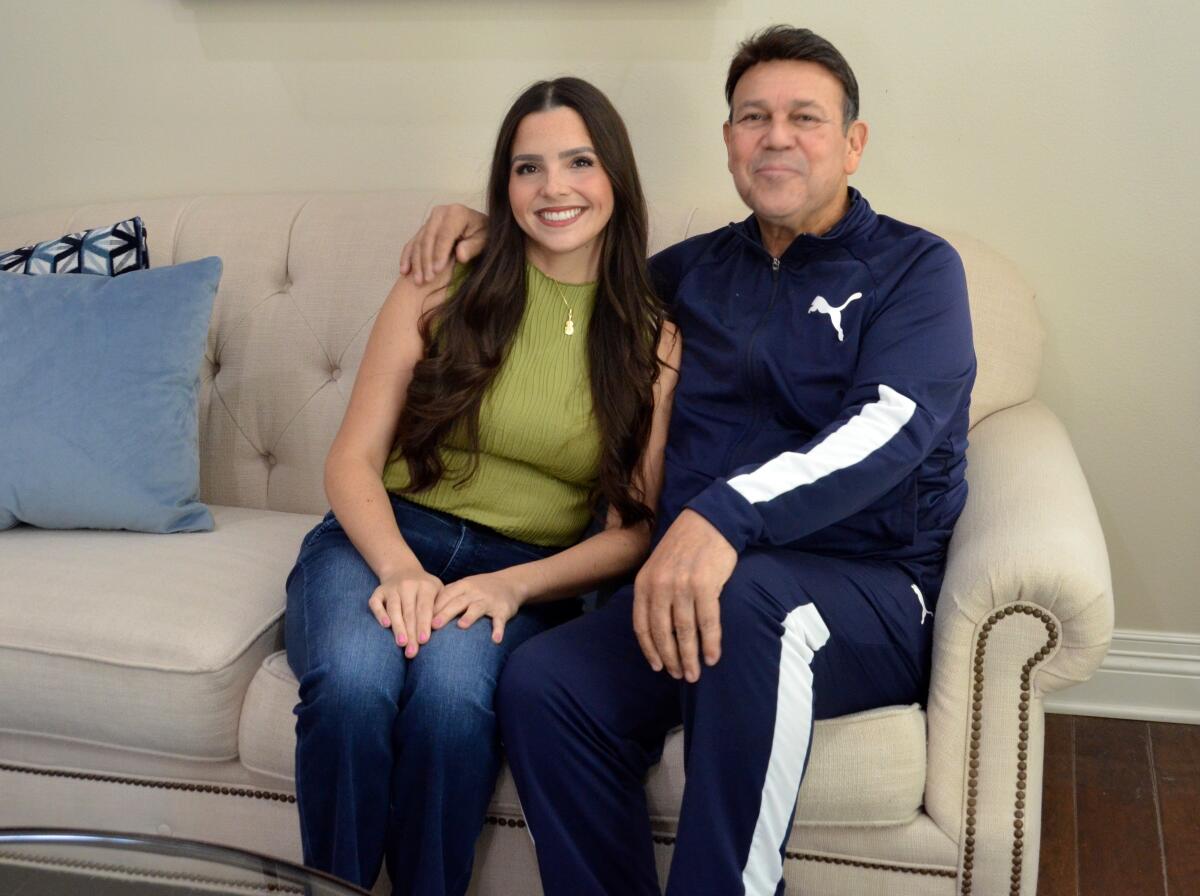 Crystal Hernandez is seated in her Newport Beach home with her musician father Jose Hernandez, who founded Mariachi Reyna.