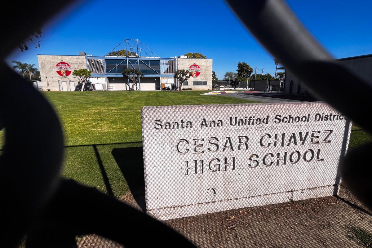 Chainlink fence casts a shadow on the signage in front of Cesar E. Chavez 