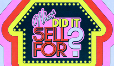 A woman with long brown hair wearing a blue top and a black textured jacket looks calmly at the camera against a plain background.