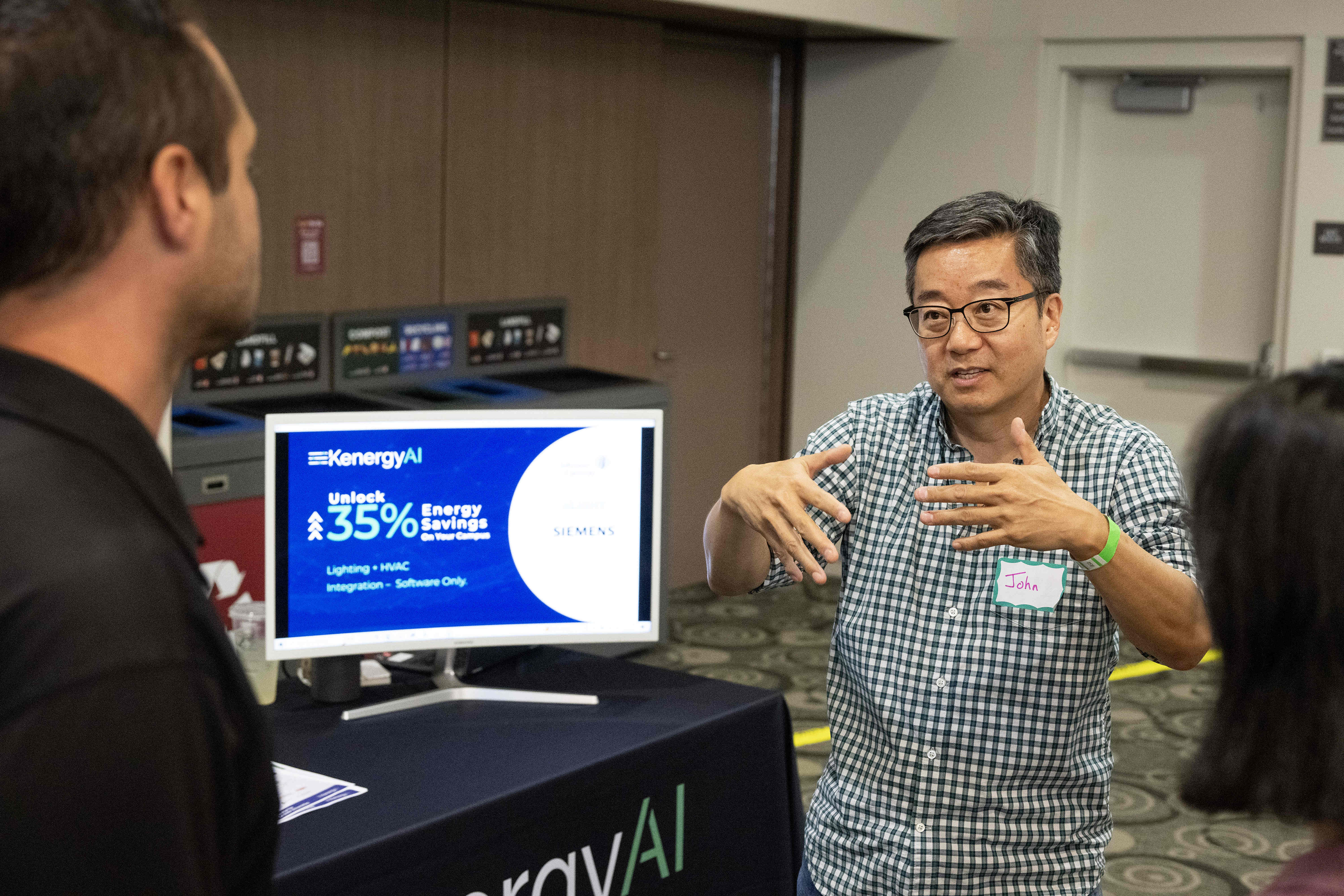KenergyAI founder John Ko, center, describes his HVAC and lighting...