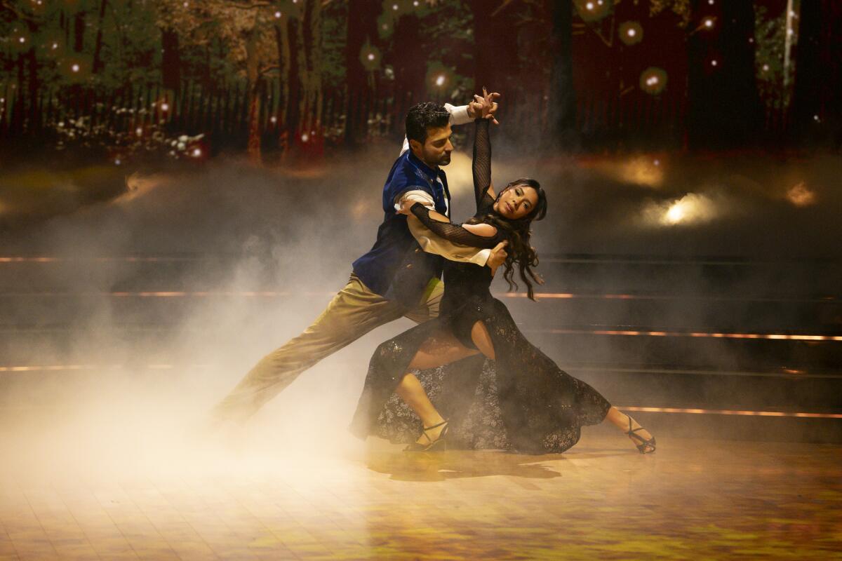 A couple dances dramatically on a dance floor with fog rolling in.
