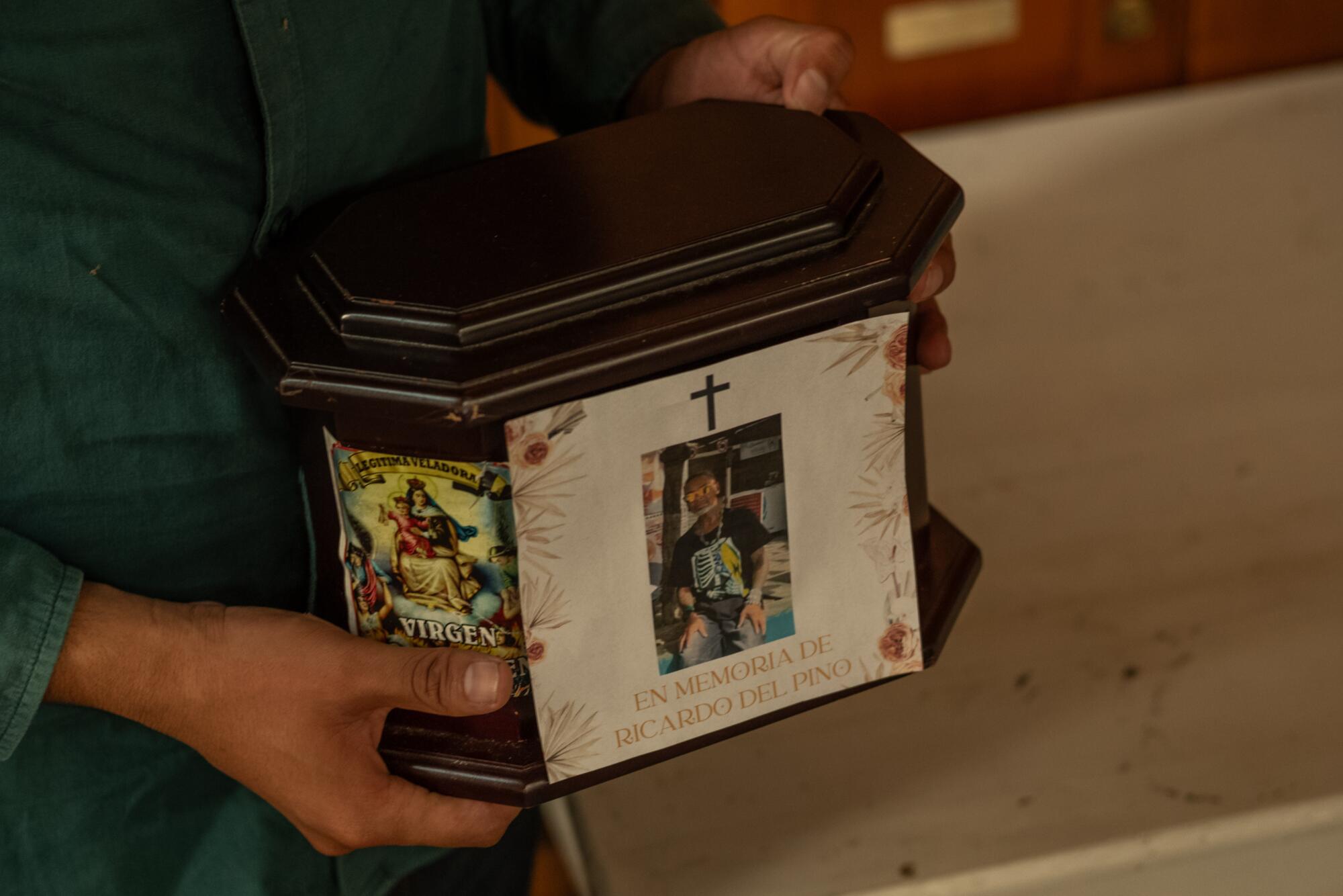 A person holds the ashes of a deported Cuban who died
