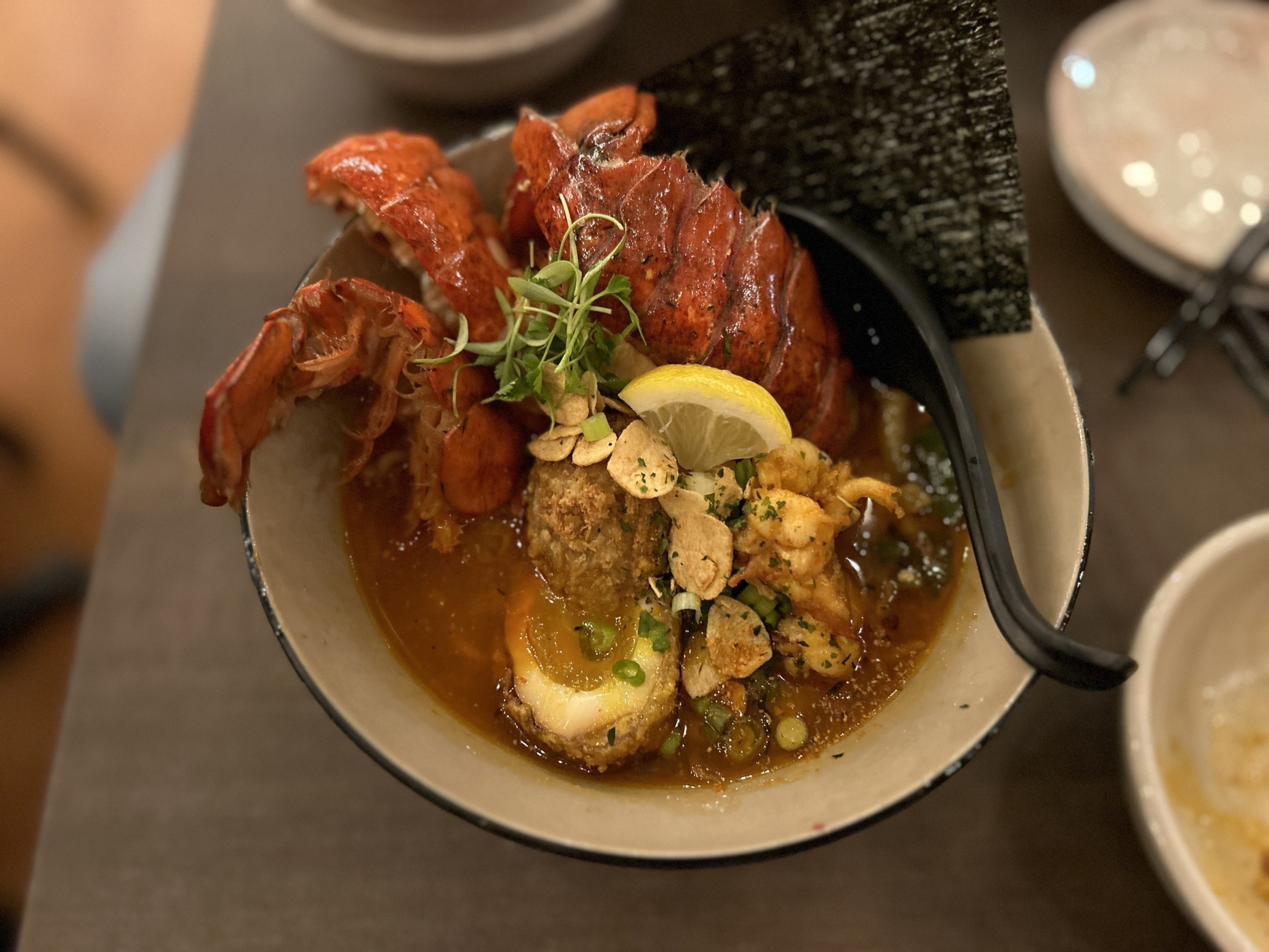 a bowl of lobster ramen with the shells poking out, shot from above