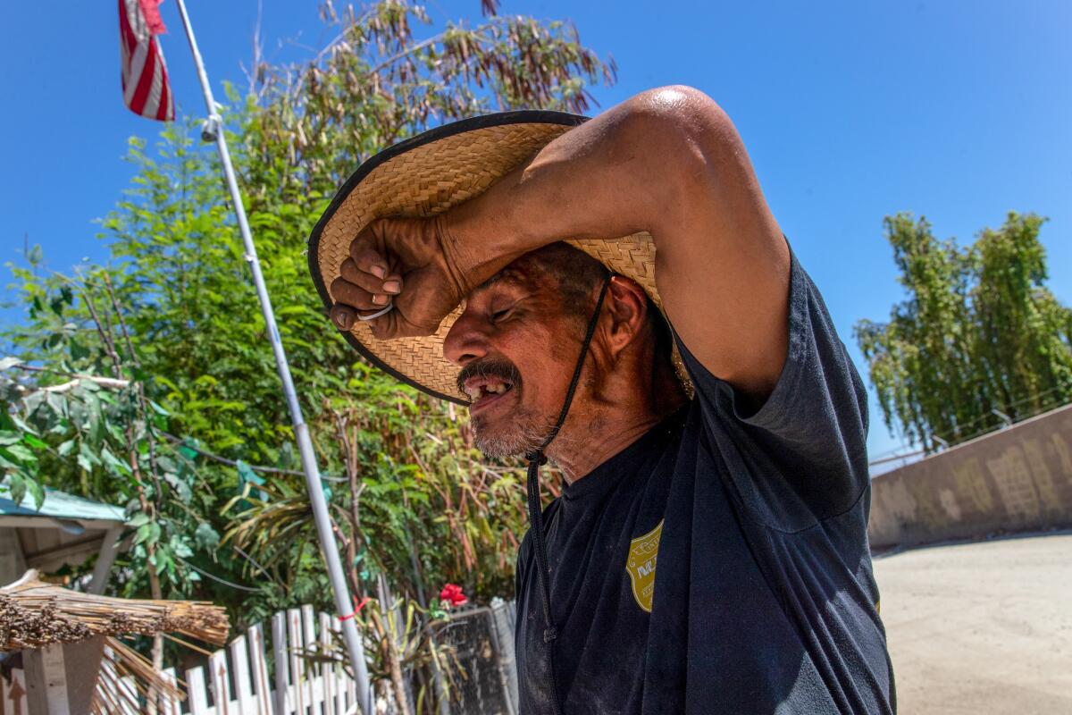 Sergio Lopez, 45, feels exhausted working around his mobile home under blazing sun.
