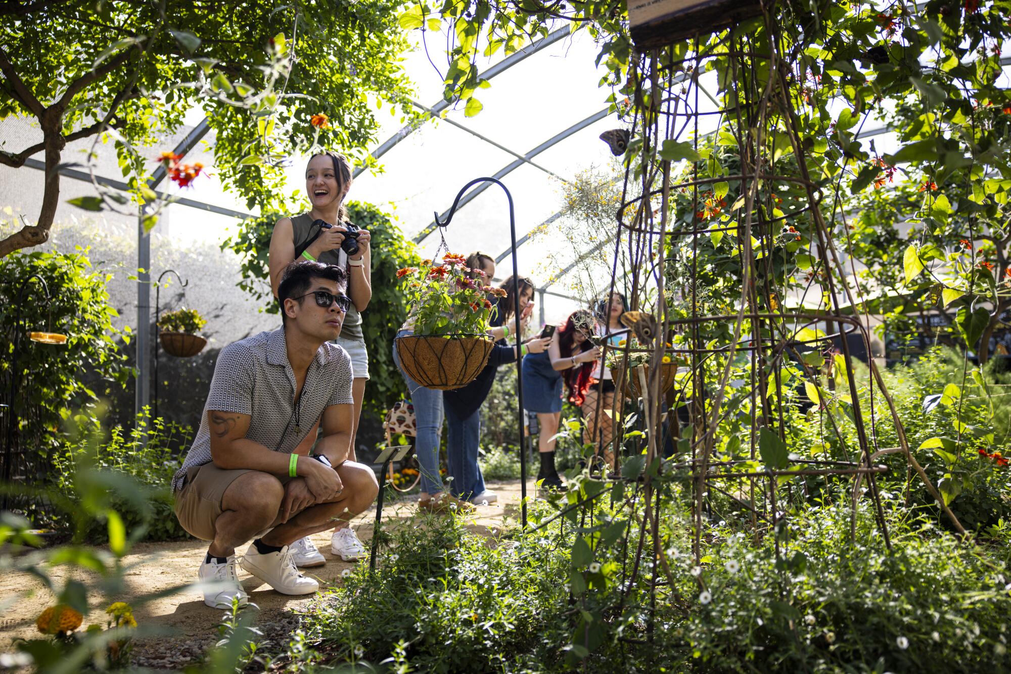 A man and woman stop on a path surrounded with plants 