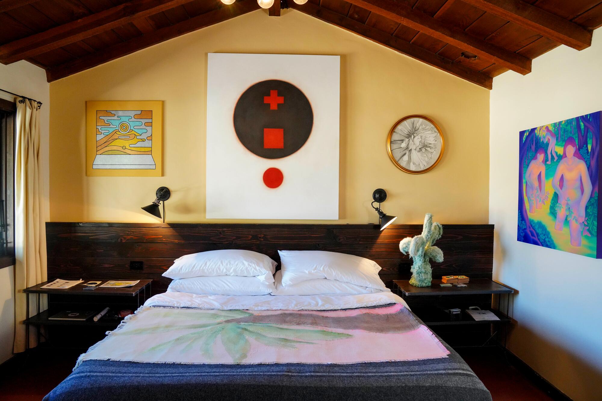 A motel room with art on the walls.