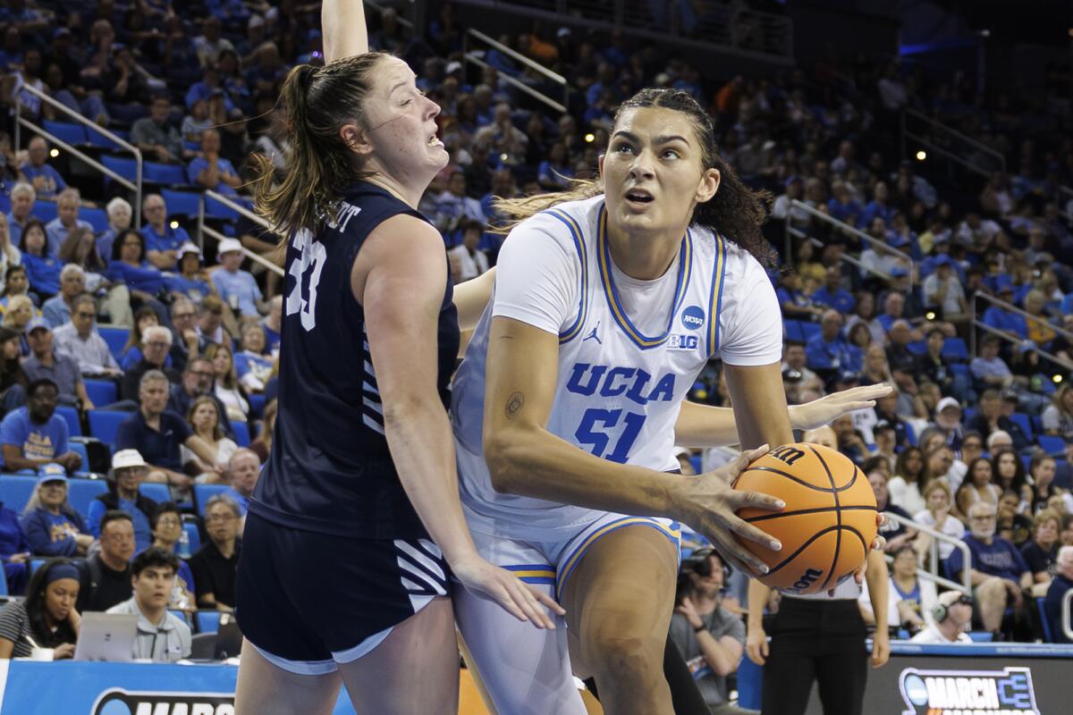 UCLA center Lauren Betts drives to the basket under pressure from California Baptist forward Grace Schmidt.