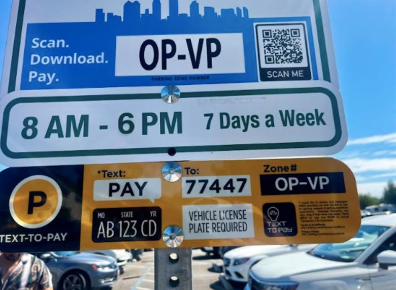Close up of a sign with a garbled square of code, called a QR code, and instructions for how to pay for parking at Balboa Park.