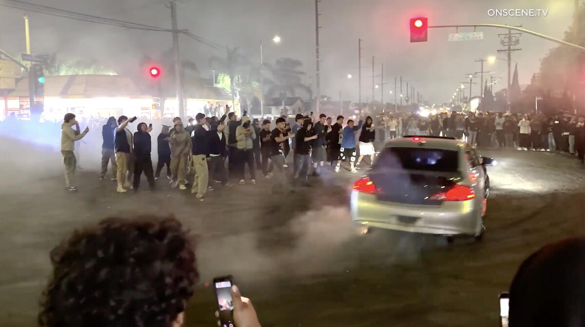 A large crowd gathered at a street takeover in the Harbor Gateway area. 