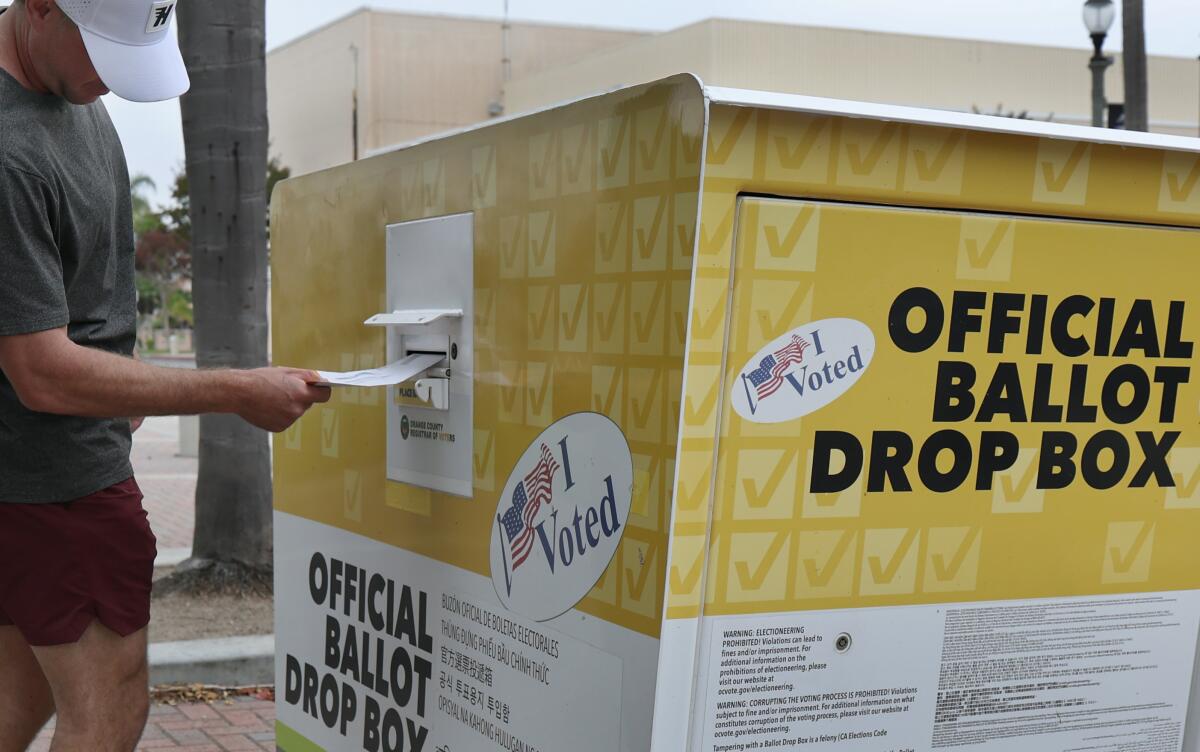 A man puts his ballot in an official ballot drop box 