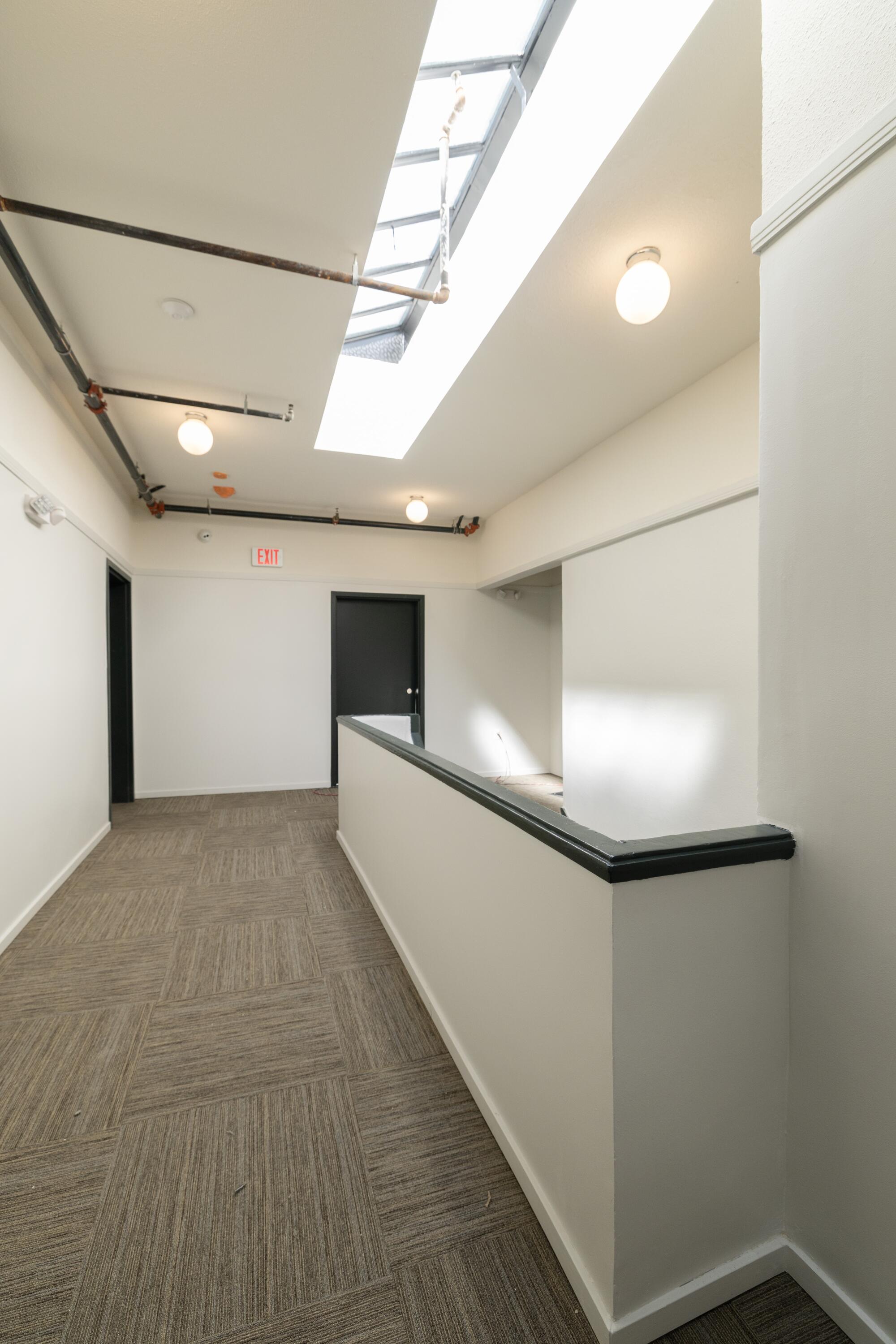 A hallway with a skylight in an apartment building.