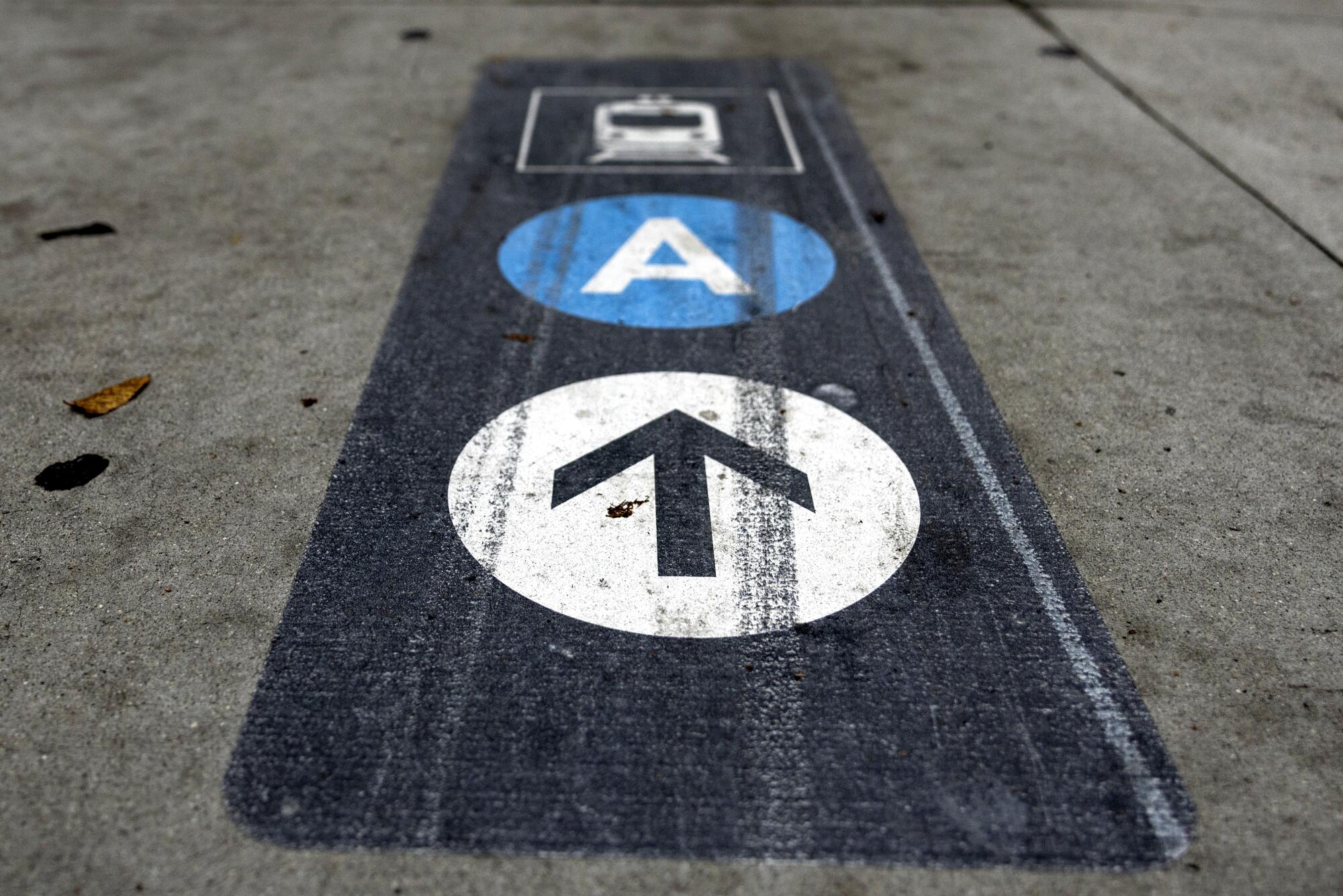 A sign painted on the sidewalk indicates the direction toward the Chinatown Metro station.
