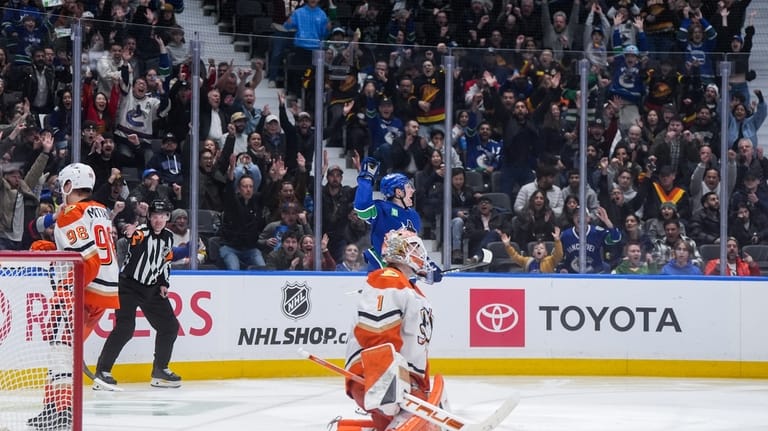 Vancouver Canucks' Drew O'Connor, back, celebrates his goal against Anaheim...