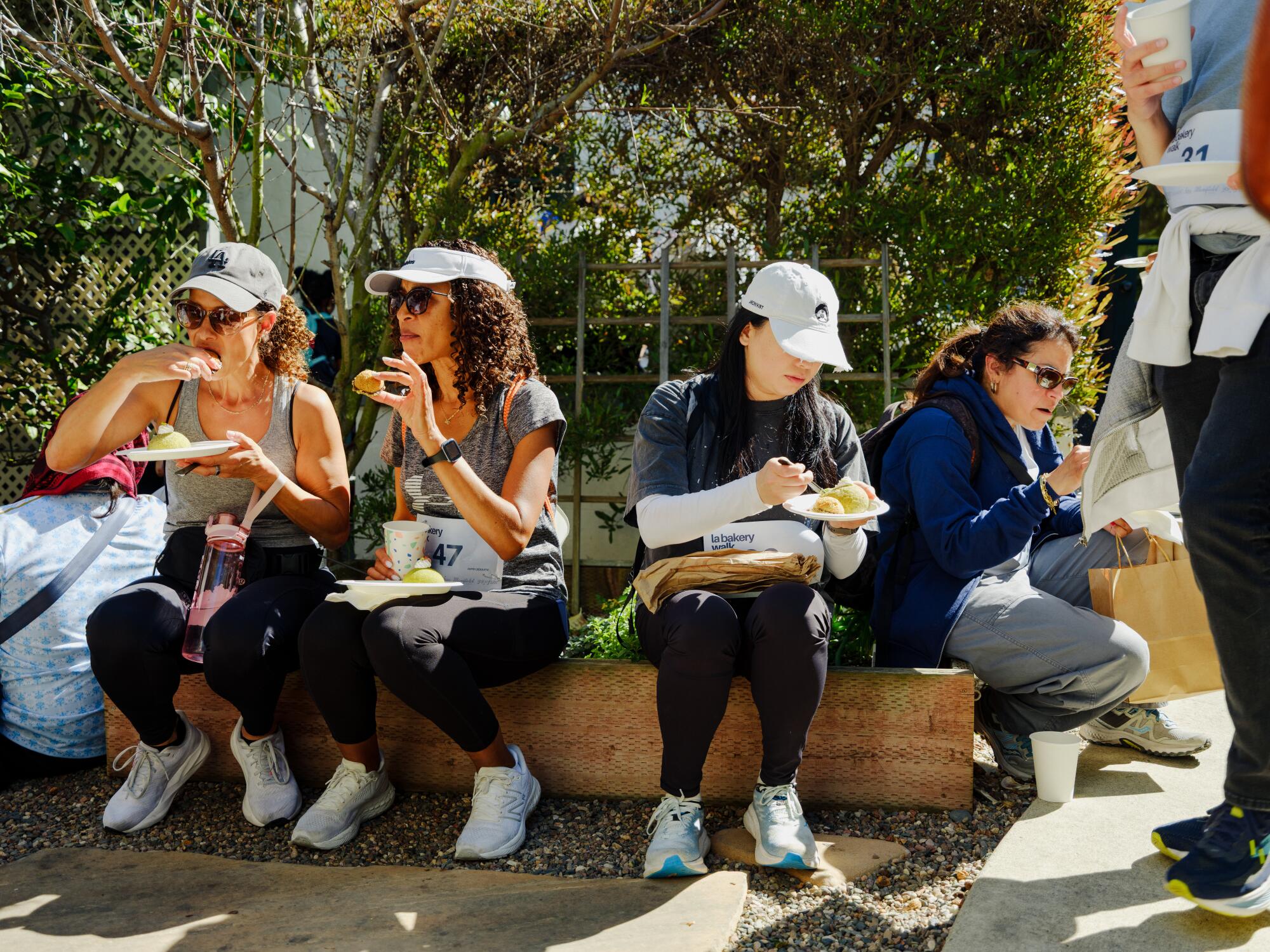 People sit in a row eating pastries.
