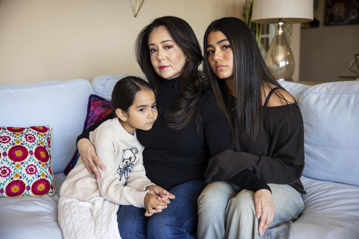 Gladdys Uribe, center, sits with her daughters Ximena Bautista, left, and Shaila Bautista.