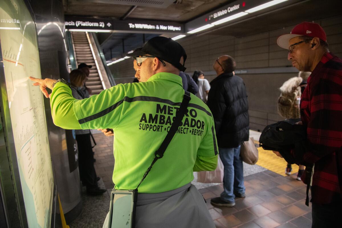 Metro Ambassador Ari Silva helps a passenger at the 7th Street / Metro Center station in 2023.